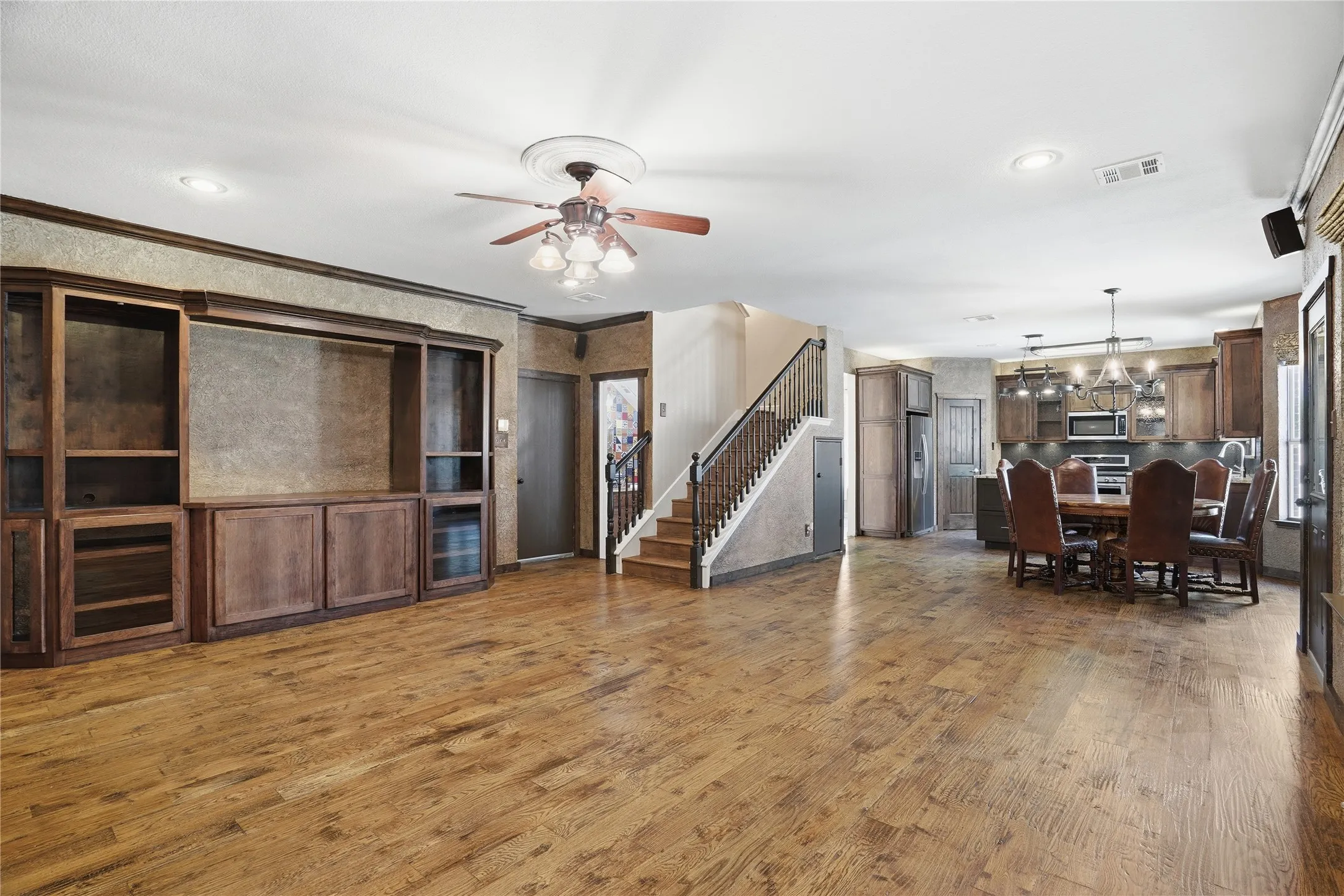 Living area featuring wood finished floors, ceiling fan, and a chandelier