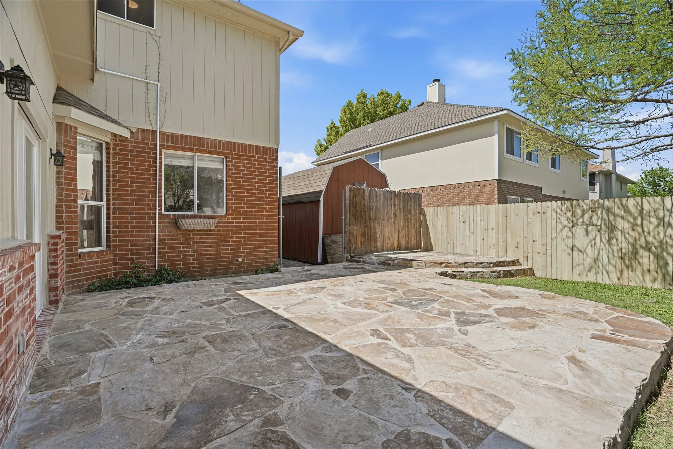 Fenced backyard with a patio and a shed