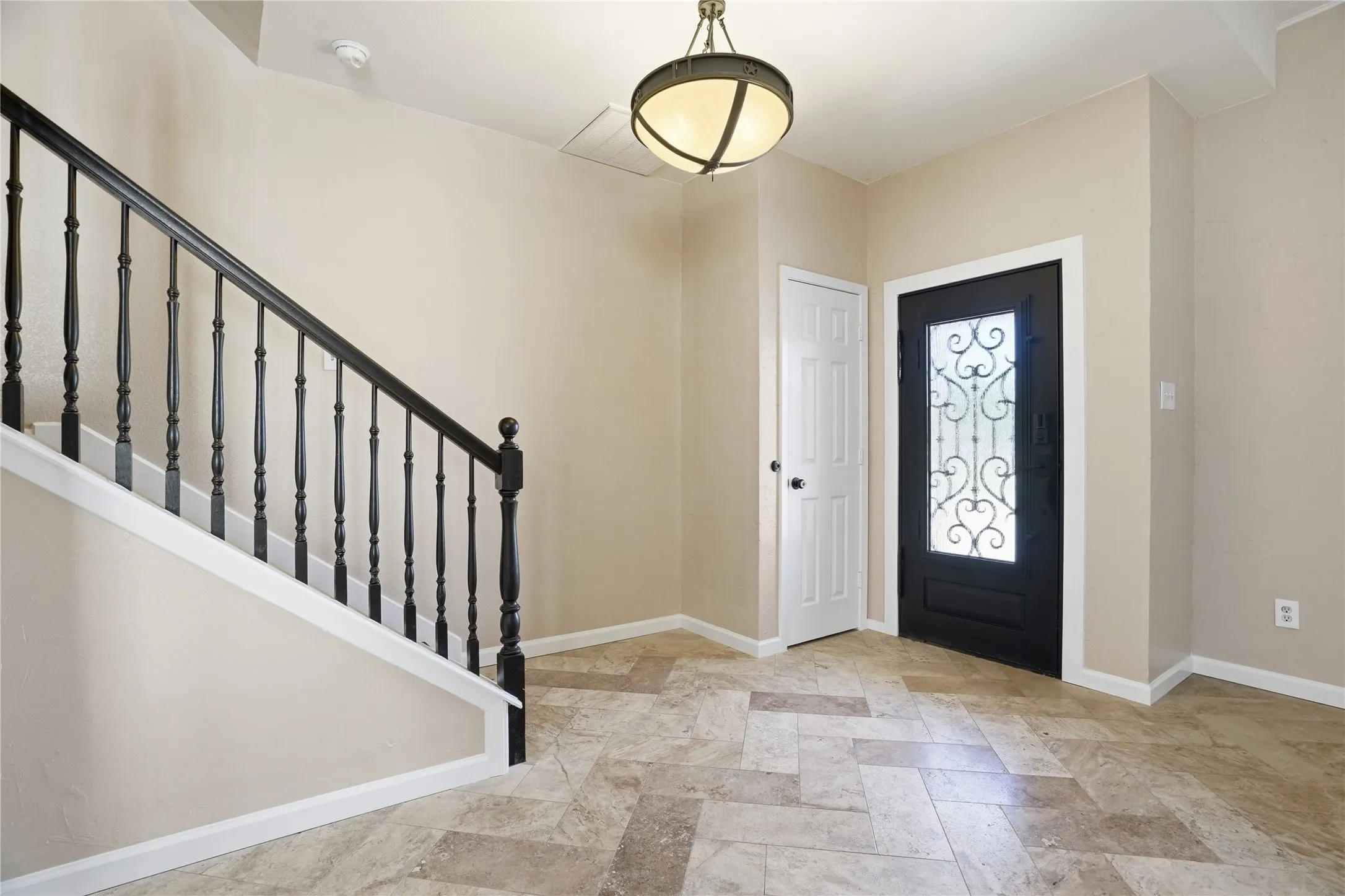 Foyer with stairway and light stone finish floors