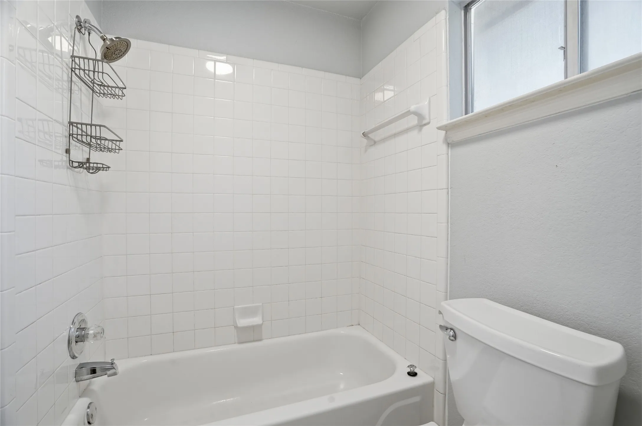 Full bathroom featuring shower / tub combination and a textured wall