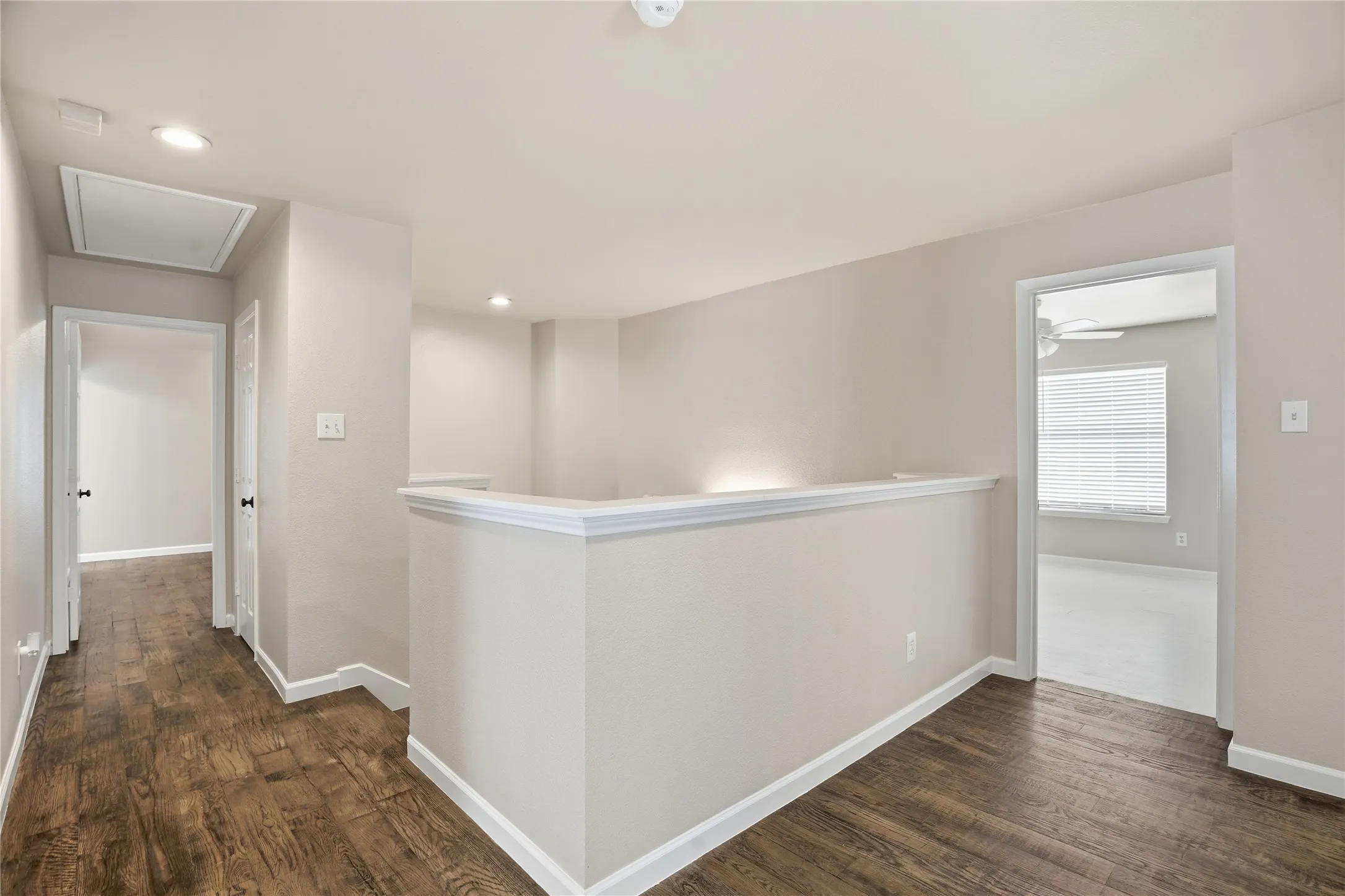 Hall featuring an upstairs landing, dark wood-type flooring, and recessed lighting