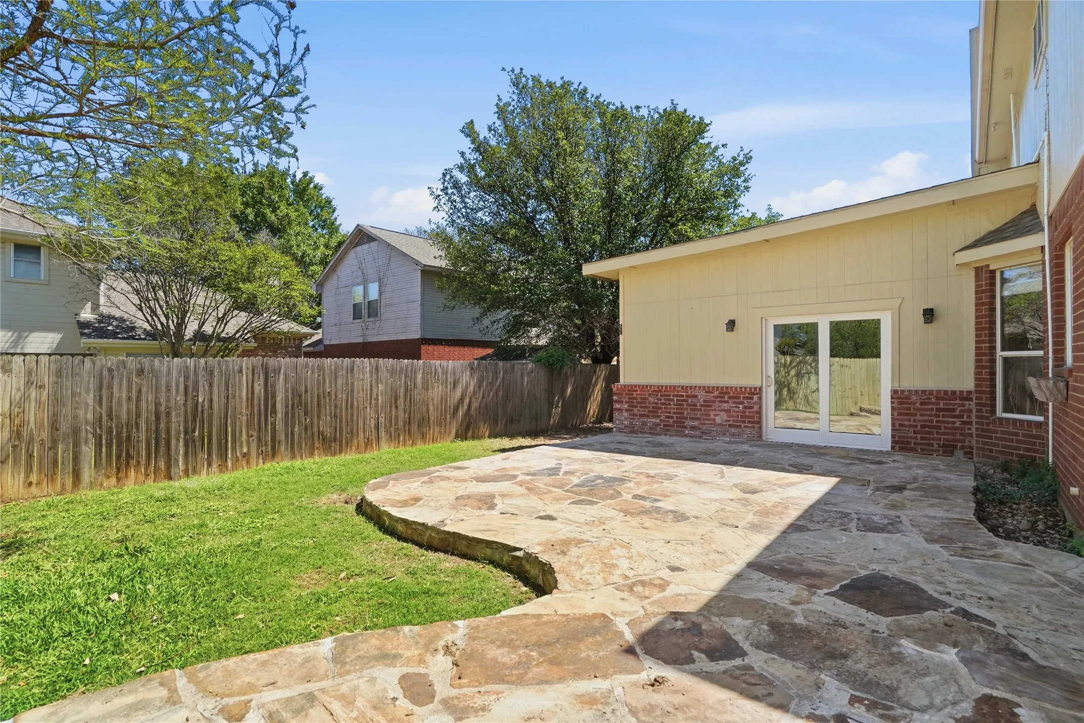 Fenced backyard with a patio area