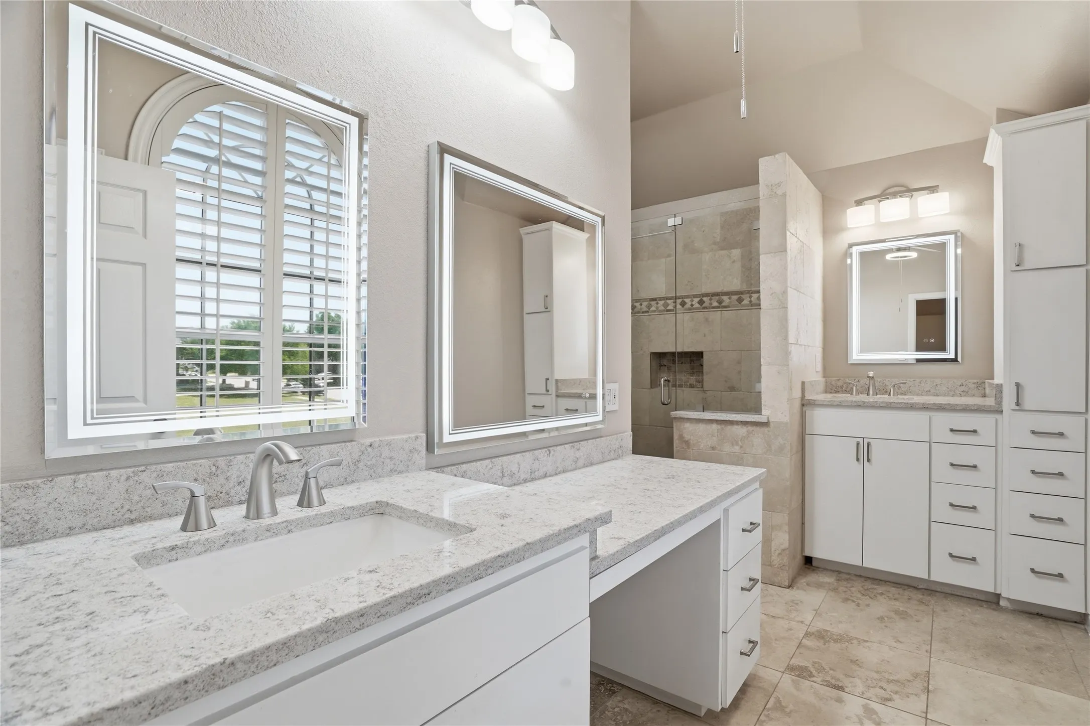 Upgraded Primary Bathroom with a shower stall and two vanities