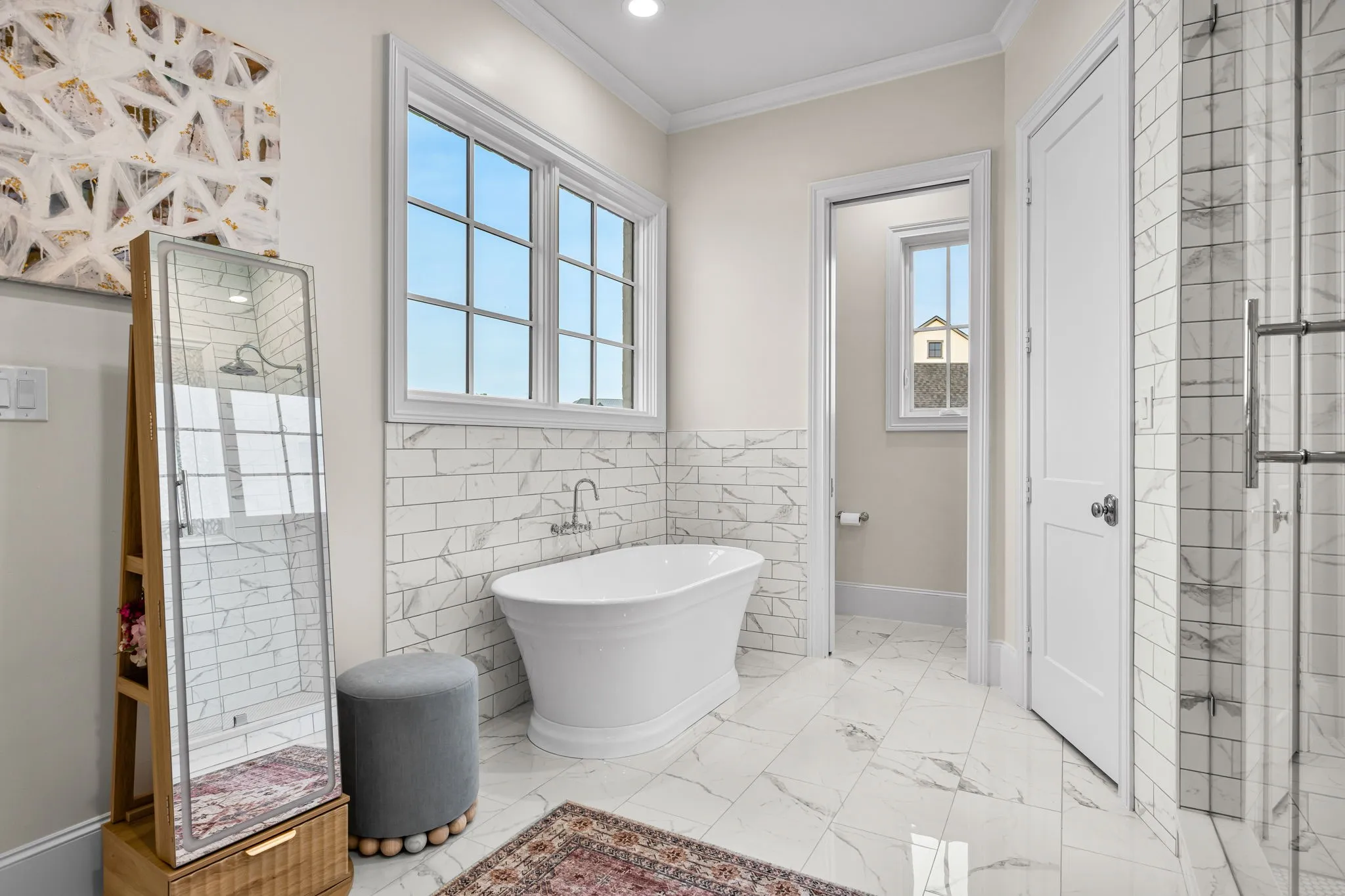 Pedestal Tub with beautiful tile backsplash and tons of sunlight to brighten the bathroom
