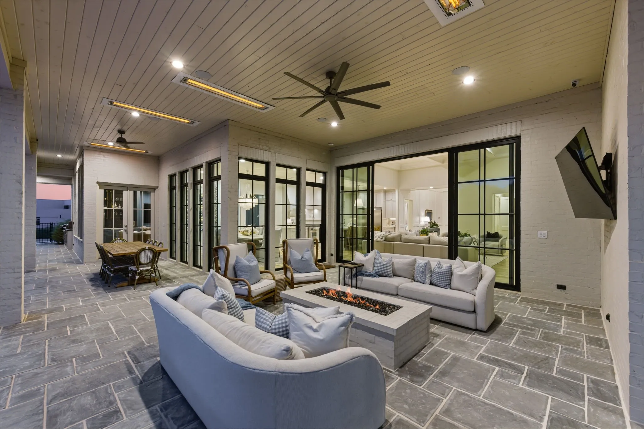 Outdoor living space, along side outdoor dining space, with built in gas tiled firepit and 4 ceiling mounted electric heaters throughout