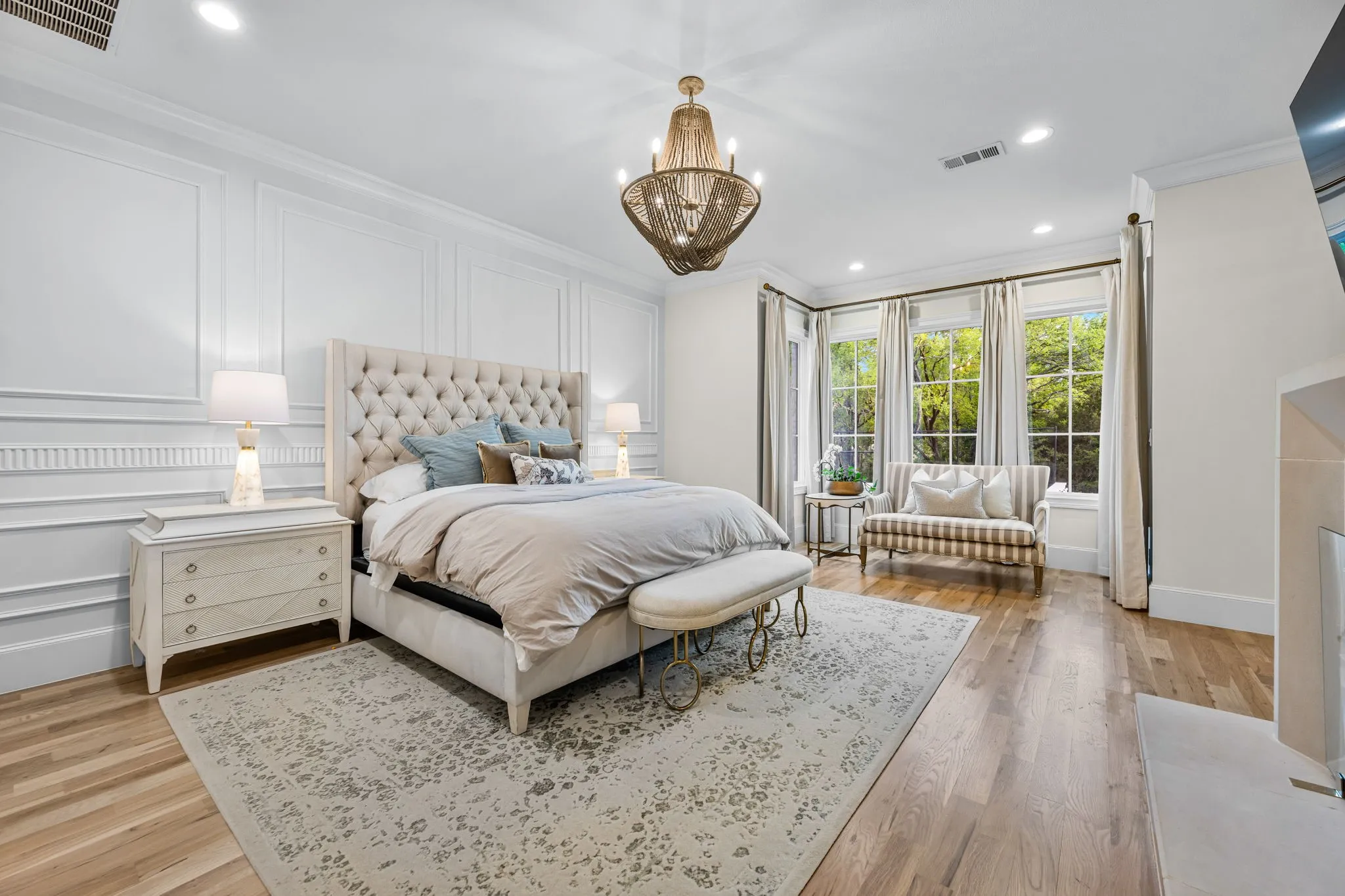 Large primary retreat with detailed picture frame molding as the backdrop