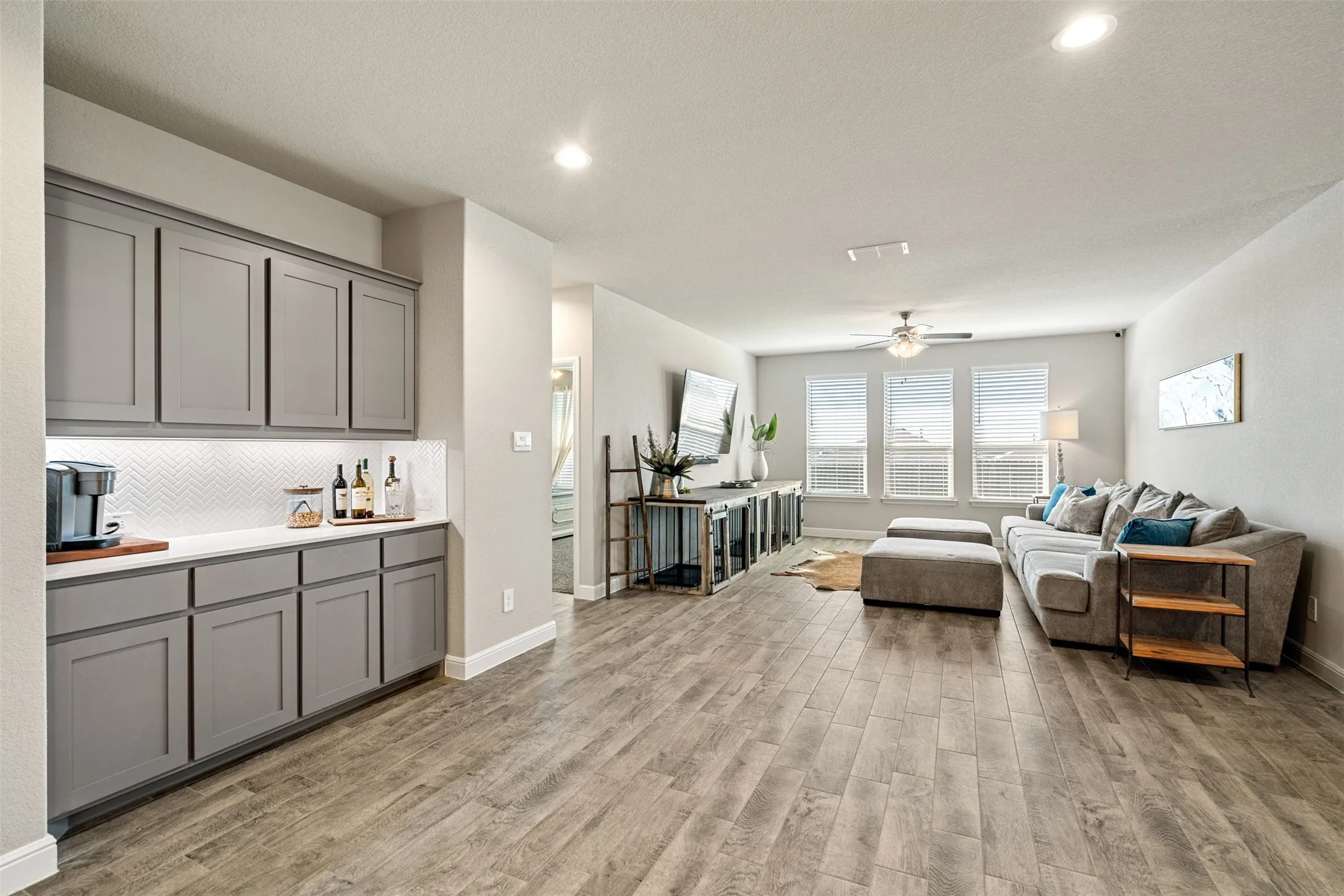Living area with recessed lighting, light wood finished floors, and ceiling fan
