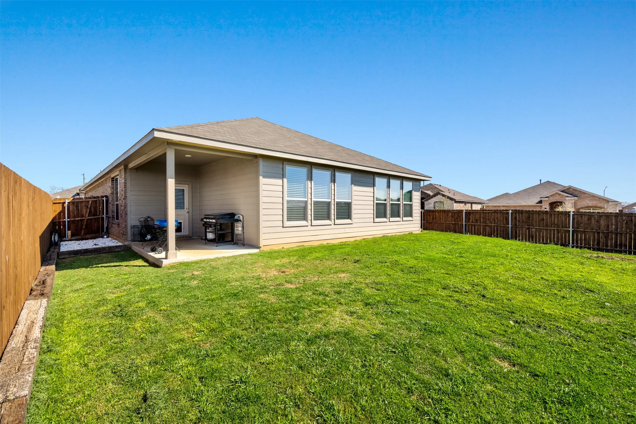 Back of property with a patio area, a fenced backyard, and a shingled roof