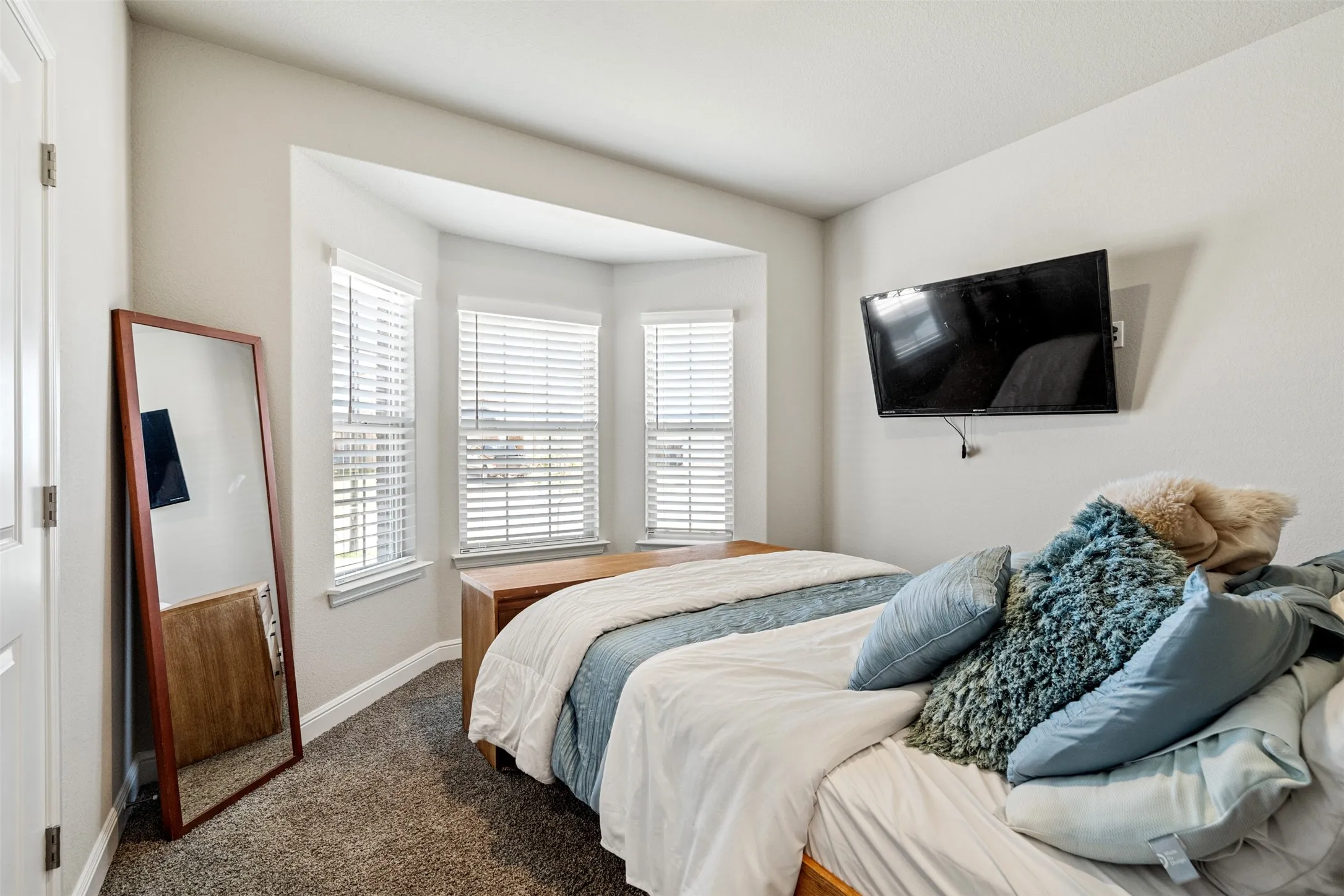 Bedroom with dark carpet and baseboards