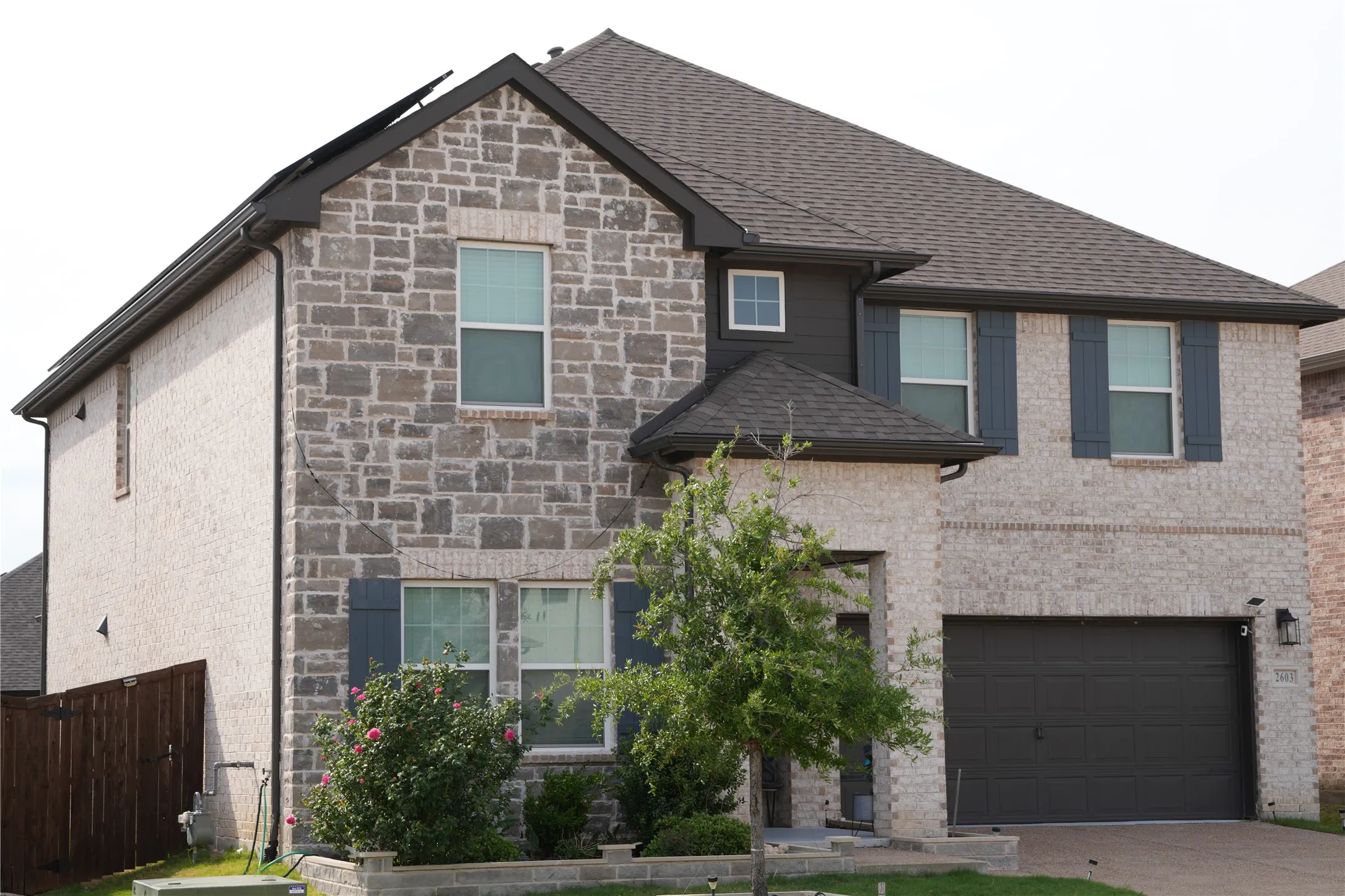 View of front of home with an attached garage, stone siding, and concrete driveway