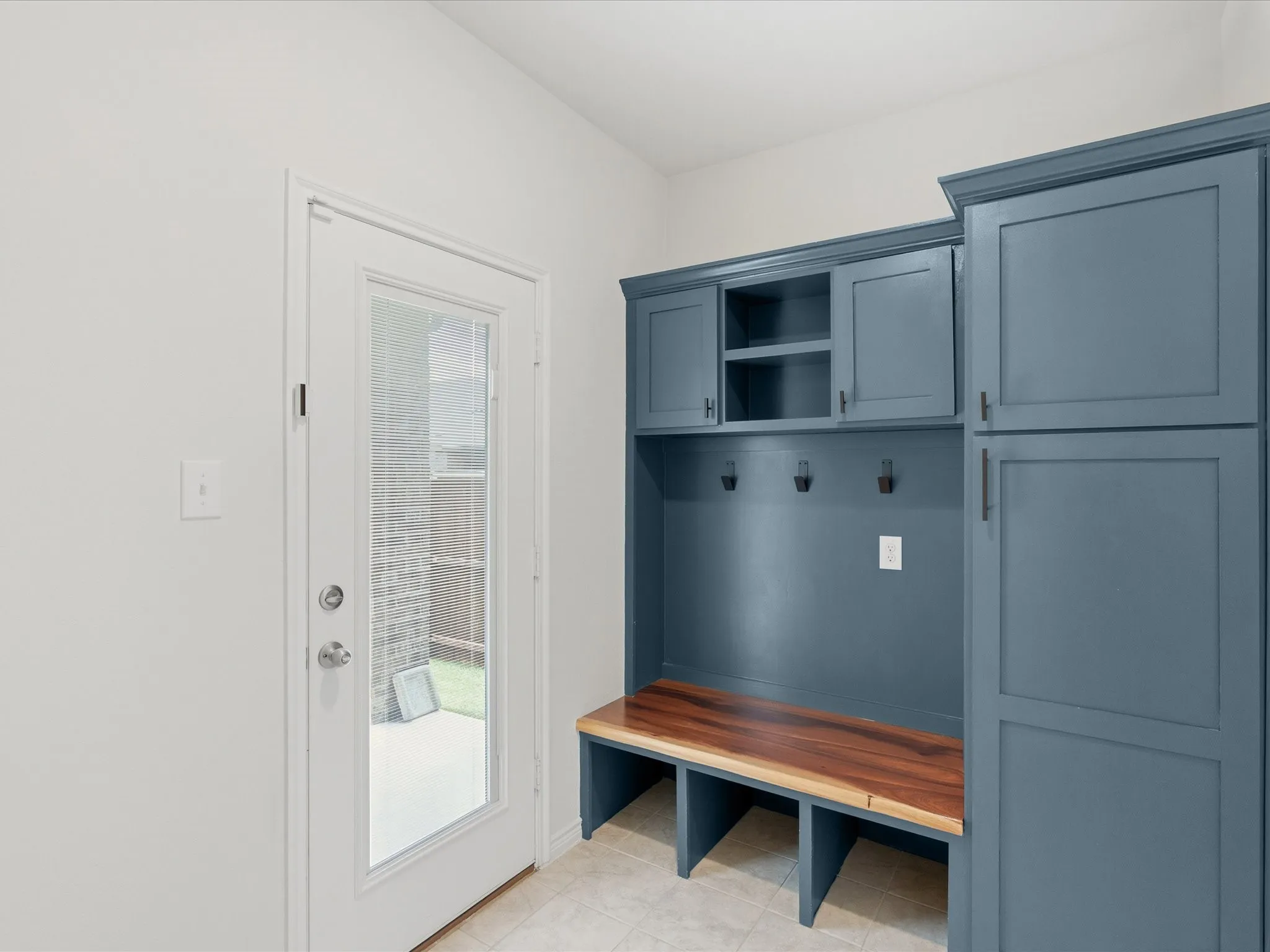 Functional laundry room upgraded with custom cabinetry creating the perfect mudroom space.