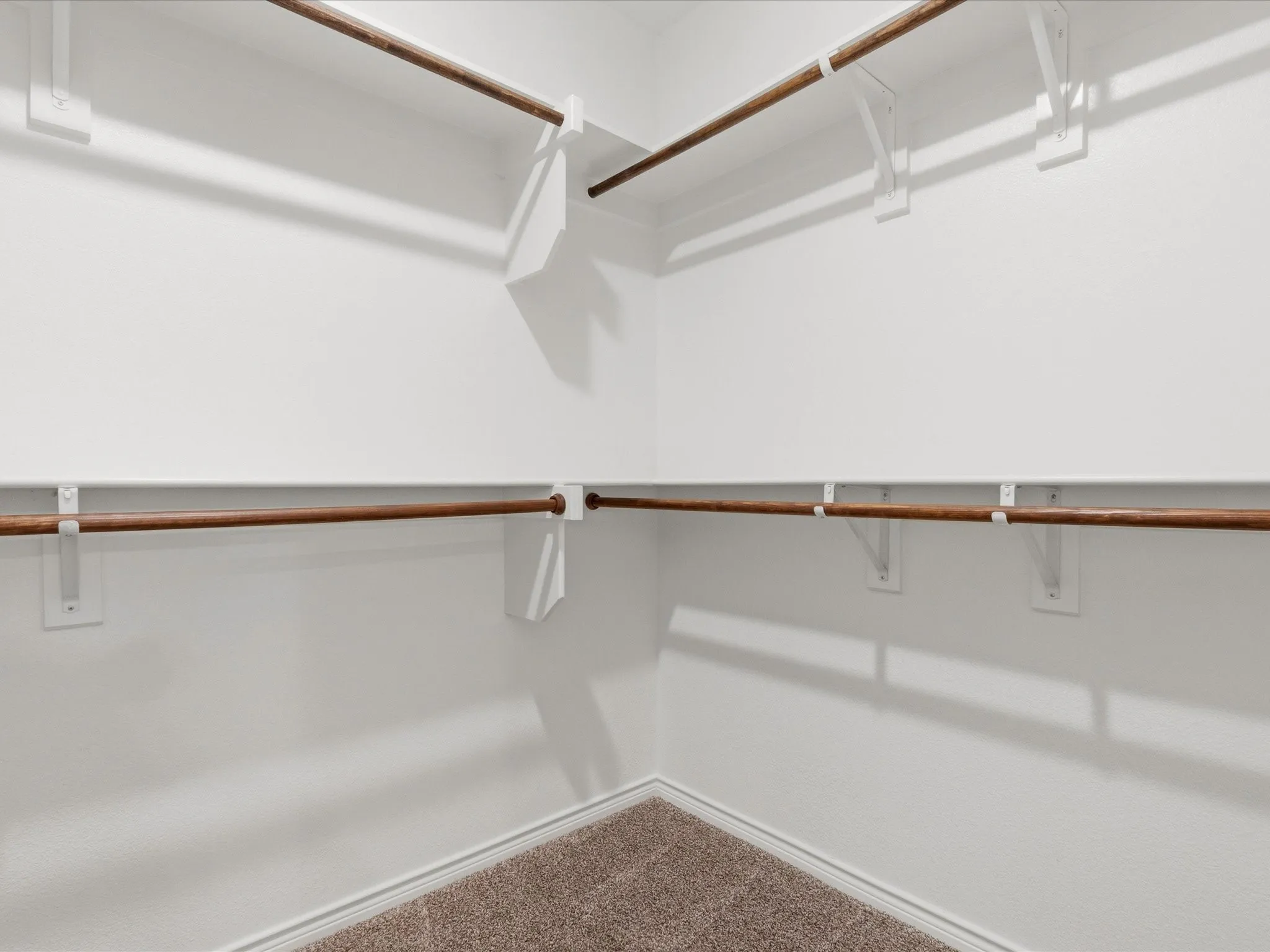 Walk-in primary closet with added custom shelving for extra organization and storage.