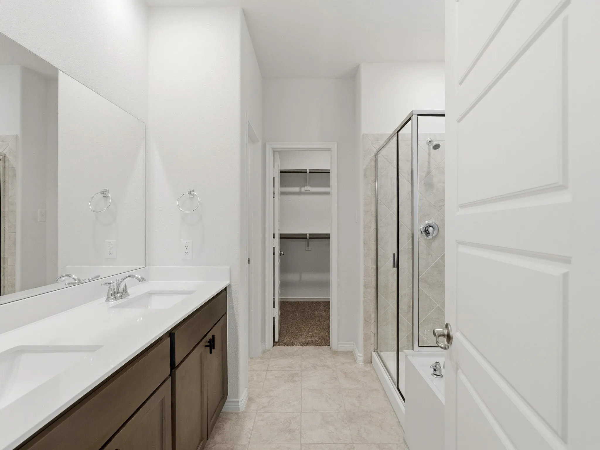 Primary bathroom with dual sinks, spacious vanity, and modern finishes.