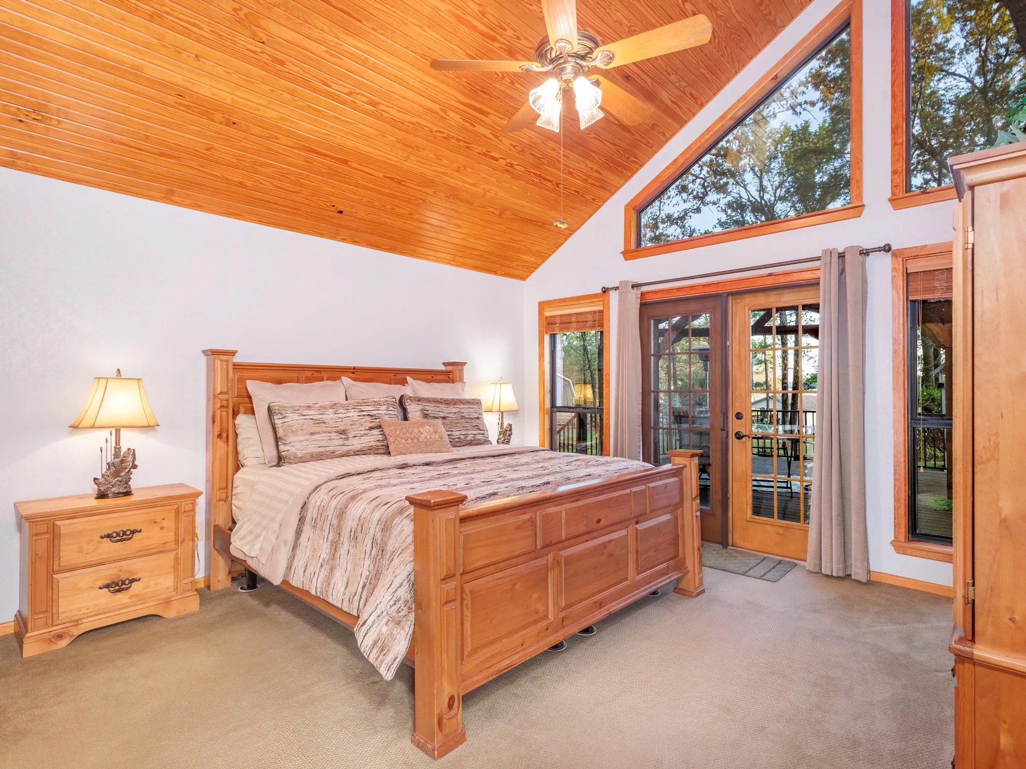 Bedroom featuring light carpet, french doors, access to outside, a ceiling fan, and a vaulted wooden ceiling