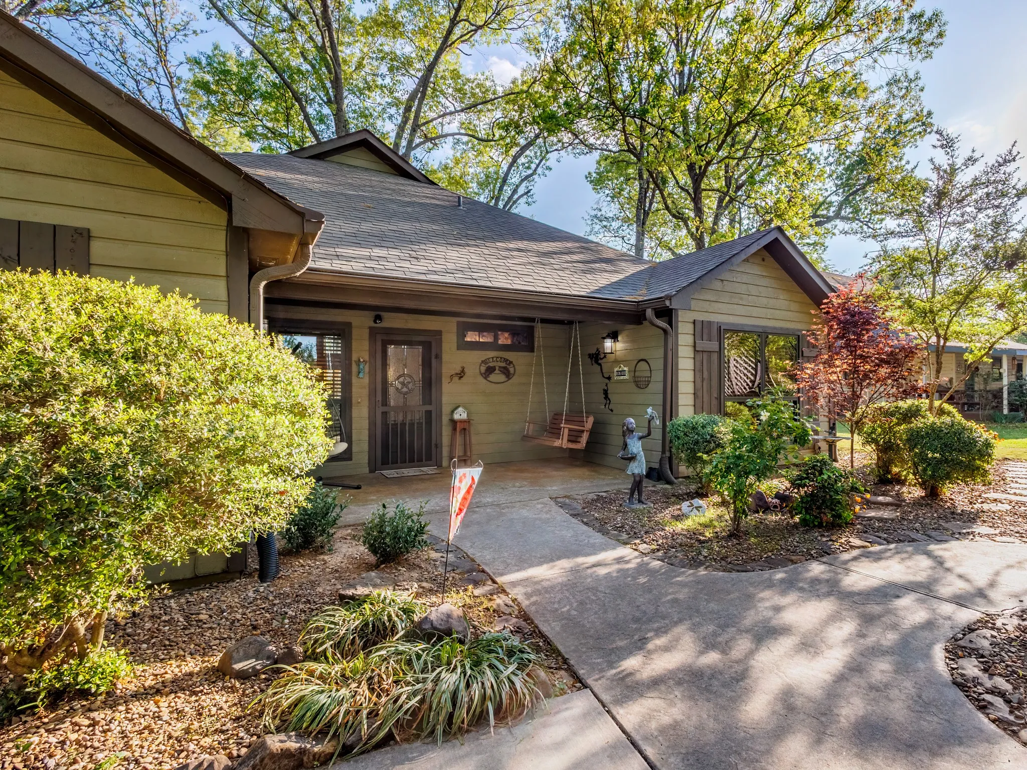 Doorway to property with a porch and roof with shingles