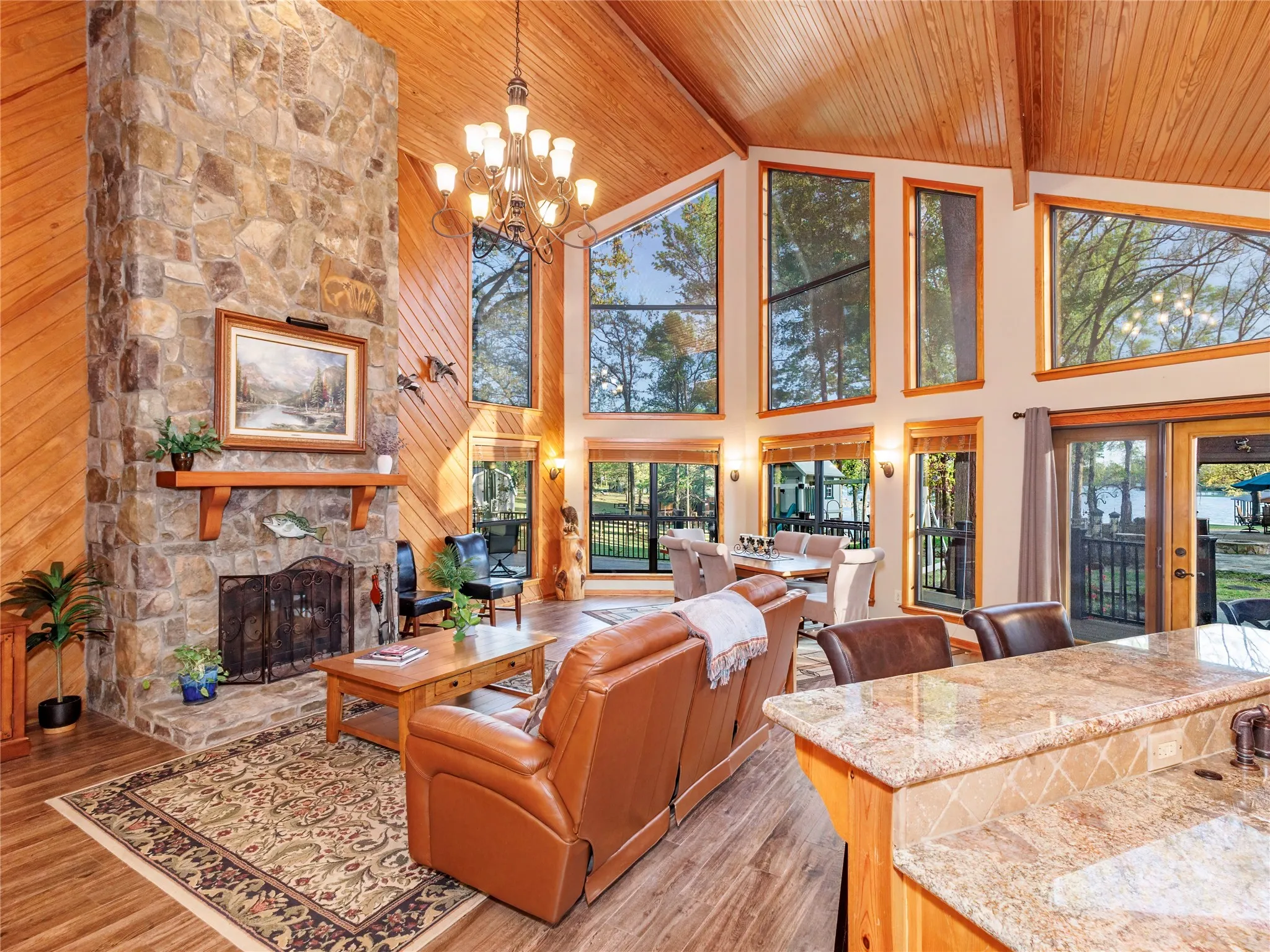 Living area with a fireplace, light wood-style flooring, hanging lights, a high wooden beamed ceiling, and french doors