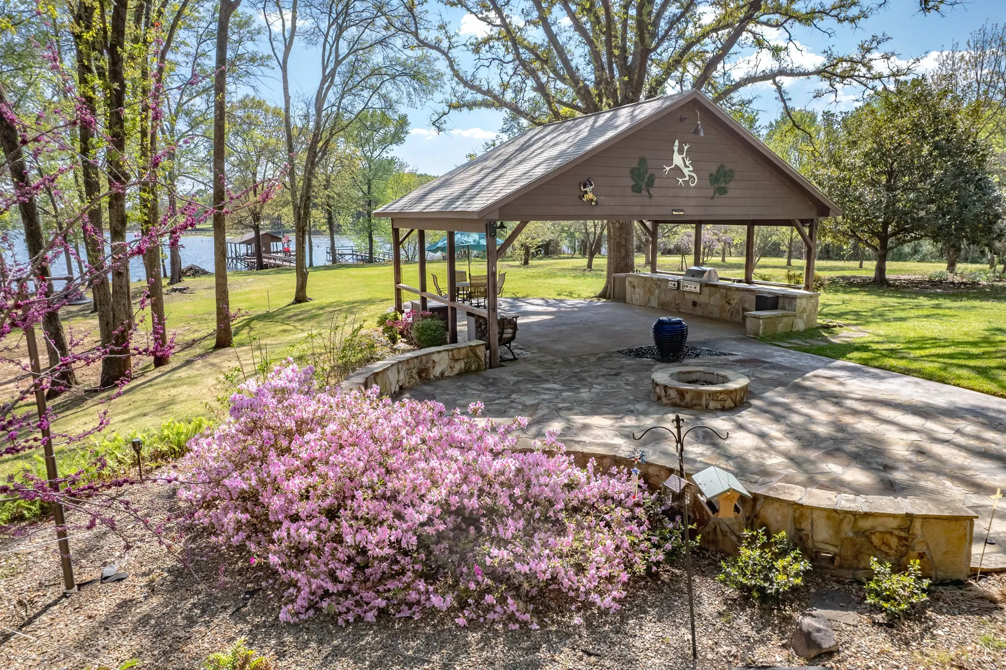 Outdoor Kitchen featuring an outdoor fire pit, a massive patio area, area for grilling, and a water view