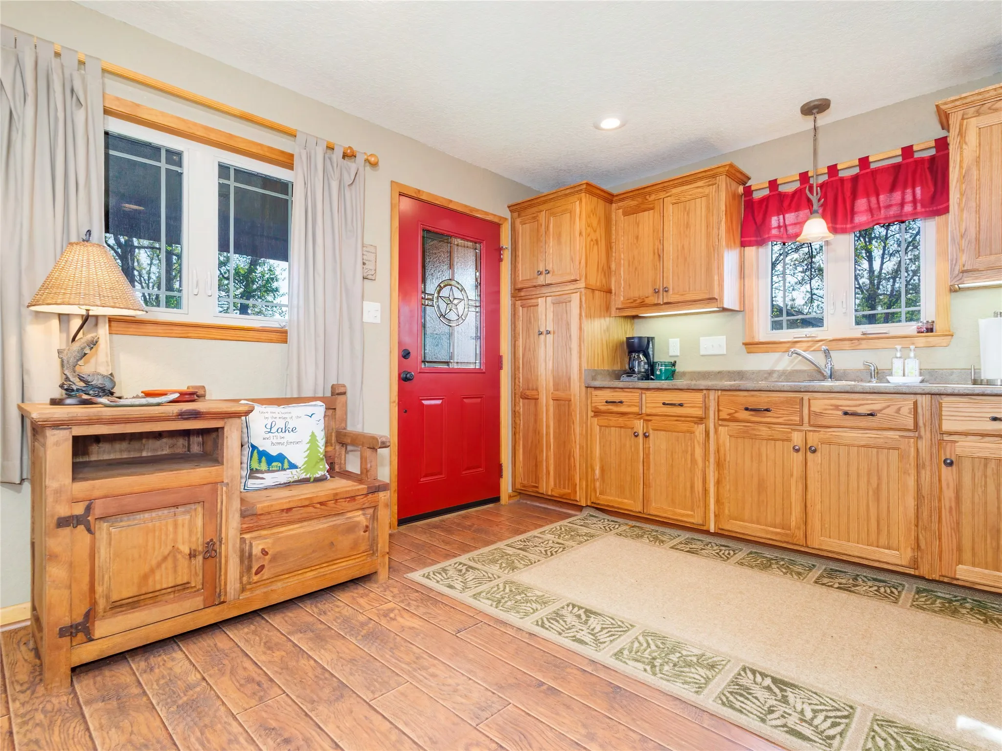 Guest Quarters Kitchen with light countertops, decorative light fixtures, and light wood-type flooring