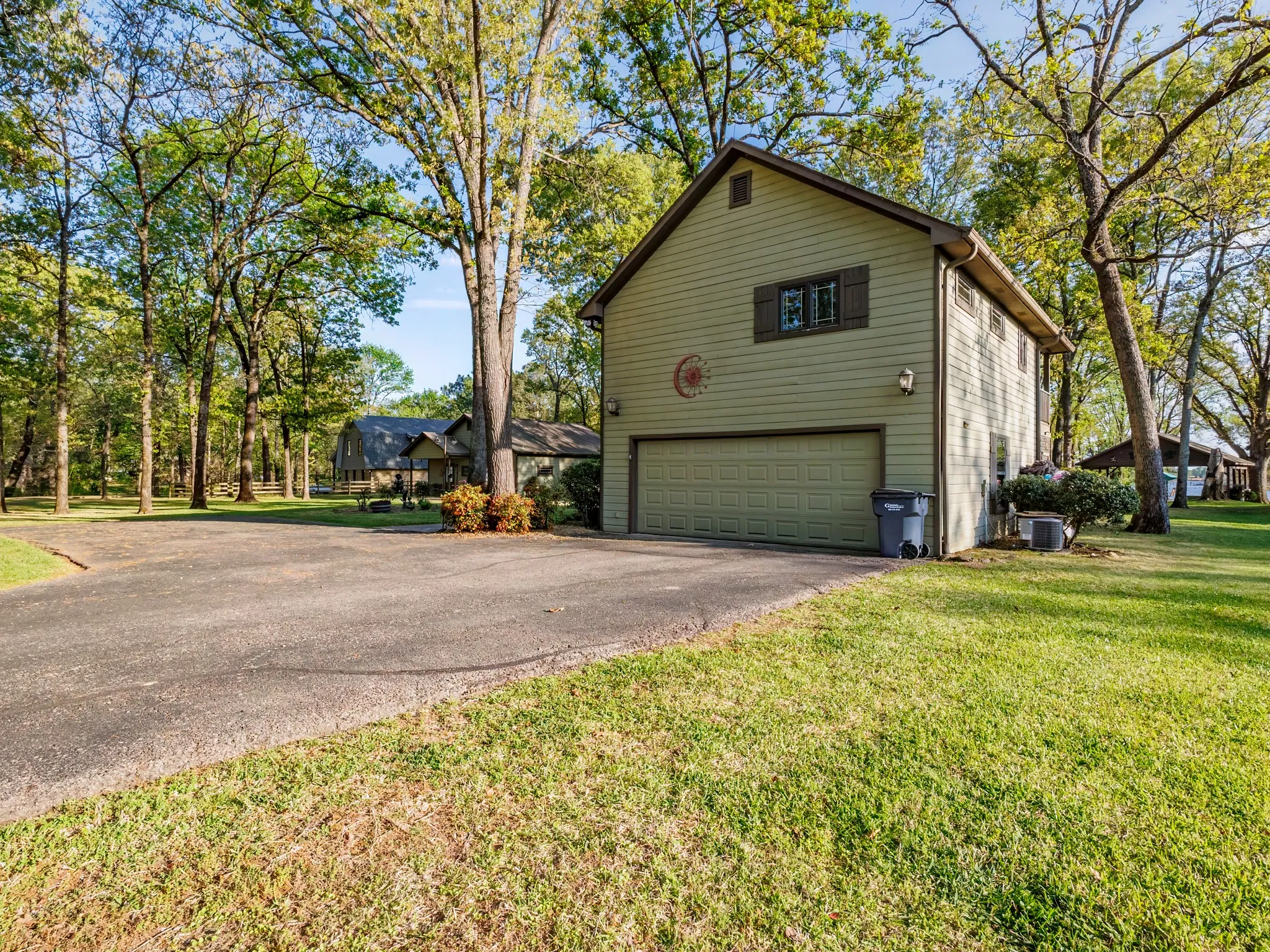 View of home's exterior featuring a lawn and asphalt driveway