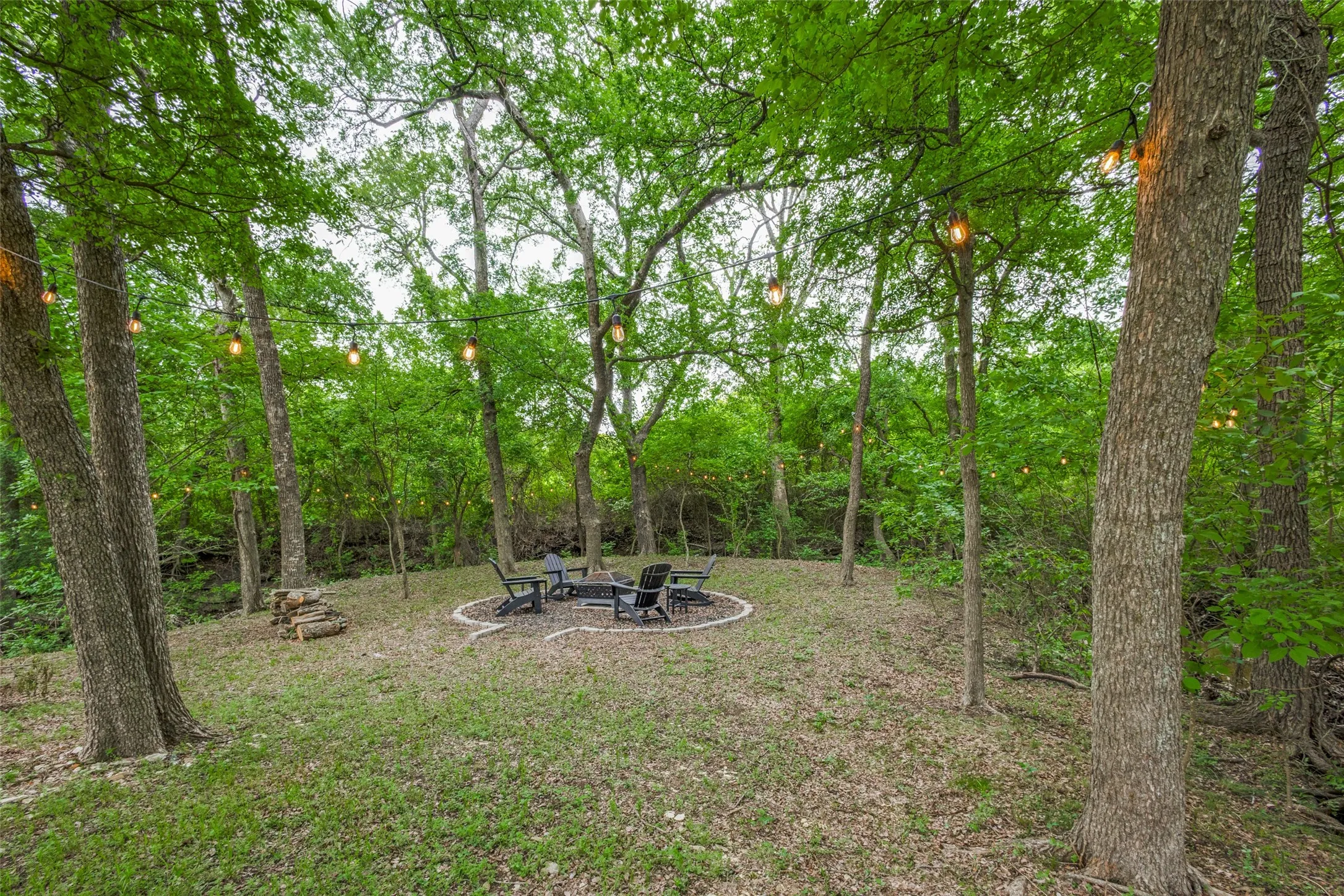 The property features a dedicated outdoor gathering space, complete with a fire pit area surrounded by chairs
