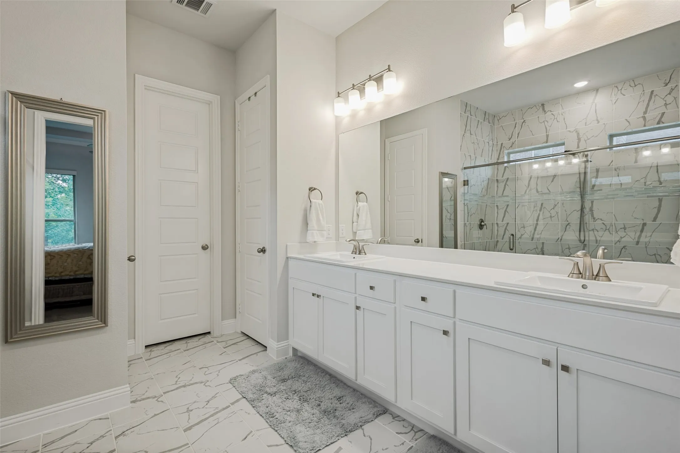 Bathroom featuring dual vanity with white cabinetry, white countertops, and undermount sinks