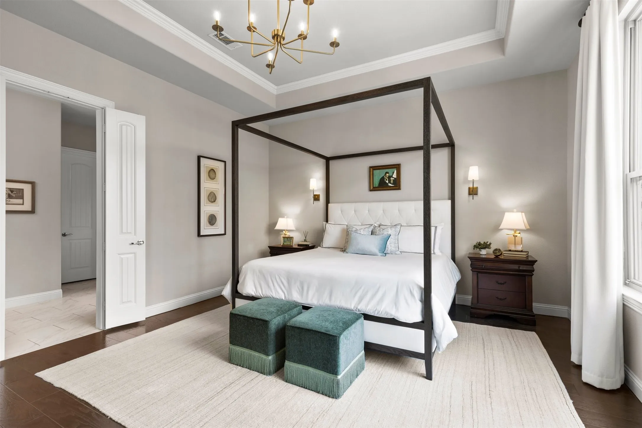 Primary bedroom with ensuite bath. Upgraded lighting includes the opulent chandelier and light sconces.