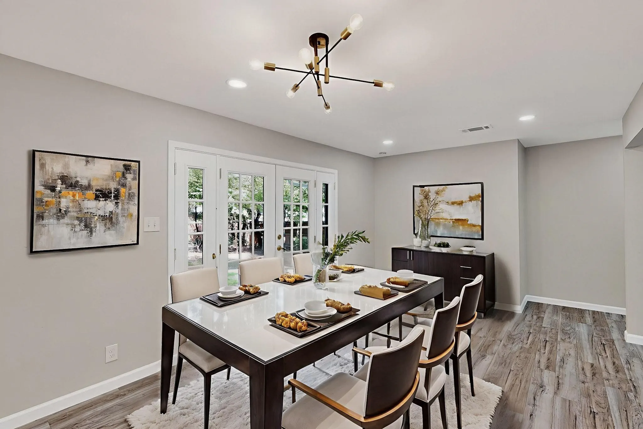Dining space with french doors, light wood-type flooring, and a chandelier
