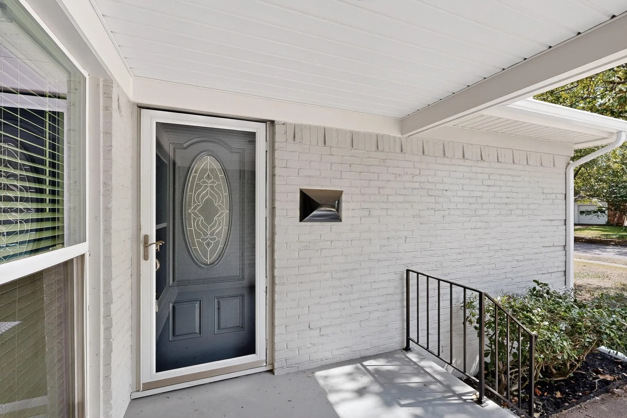 Doorway to property with brick siding and a porch