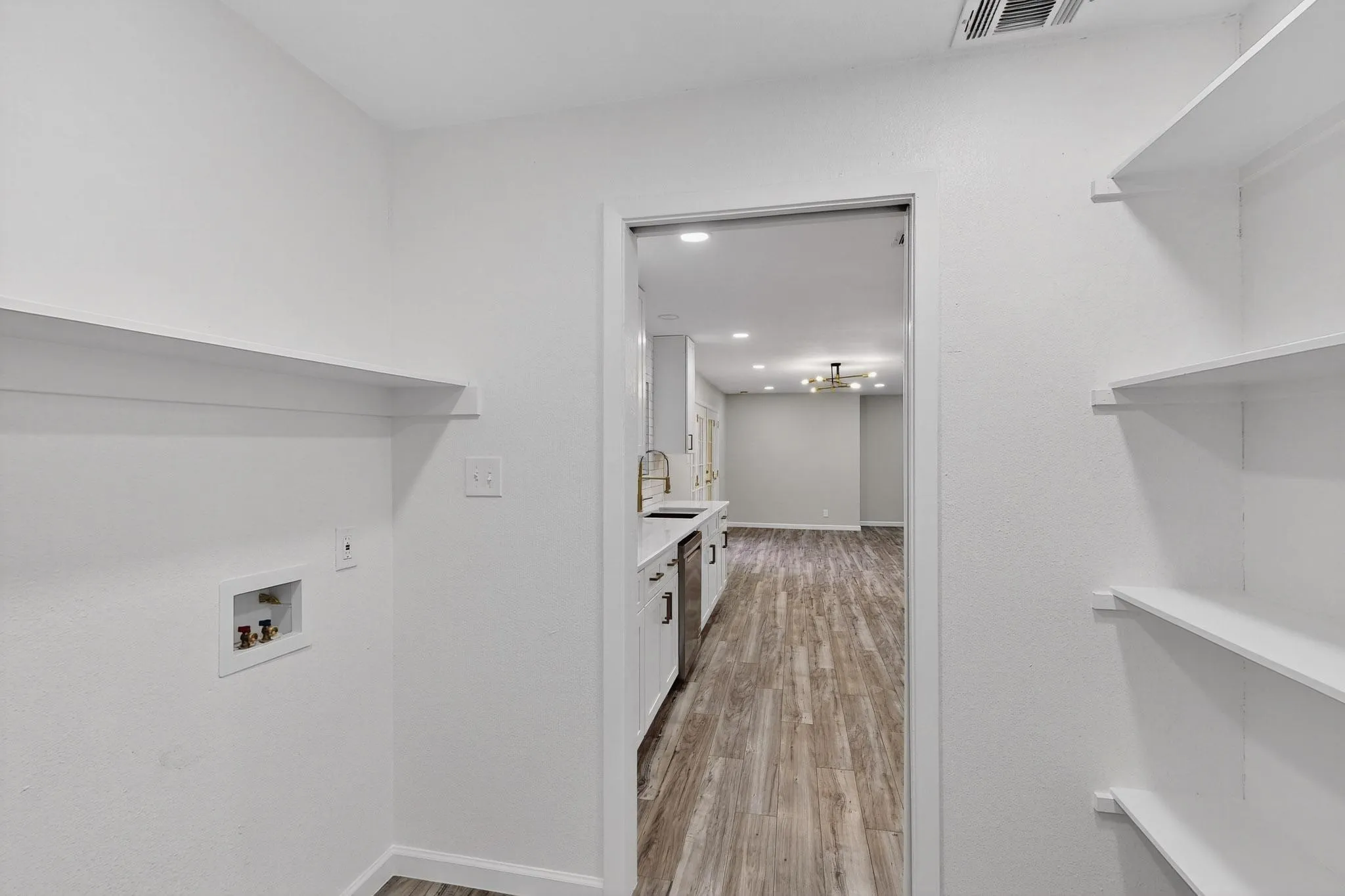 Laundry area with light wood-style flooring, hookup for a washing machine, and recessed lighting
