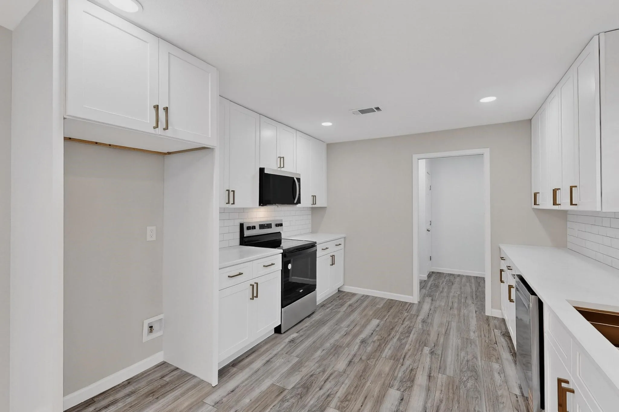 Kitchen with stainless steel appliances, white cabinets, light wood-style flooring, recessed lighting, and light stone​​‌​​​​‌​​‌‌​‌‌​​​‌‌​‌​‌​‌​​​‌​​ counters