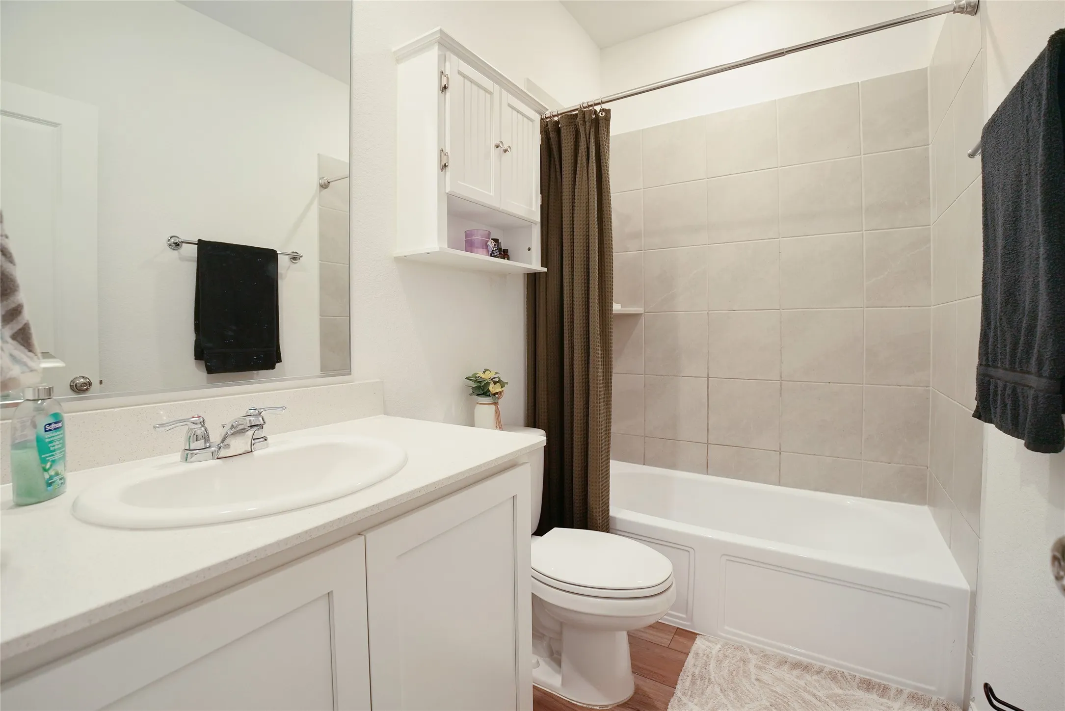 Full bath with vanity, shower / bathtub combination with curtain, and light wood-type flooring
