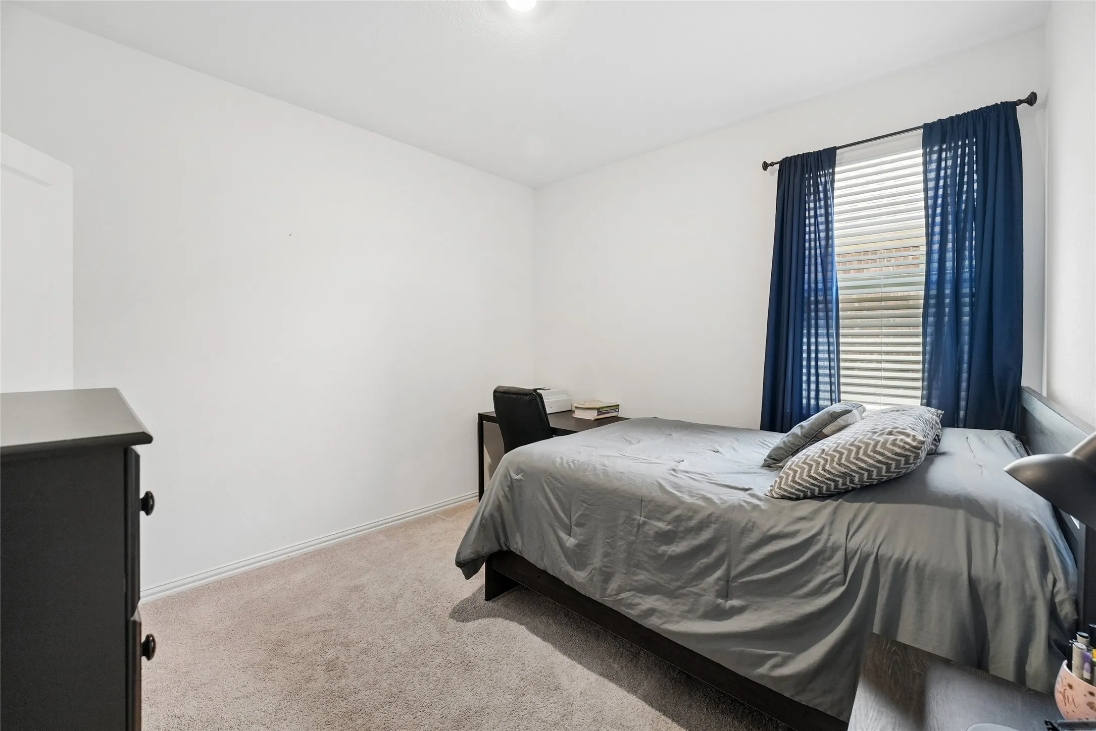 Bedroom featuring light carpet and baseboards