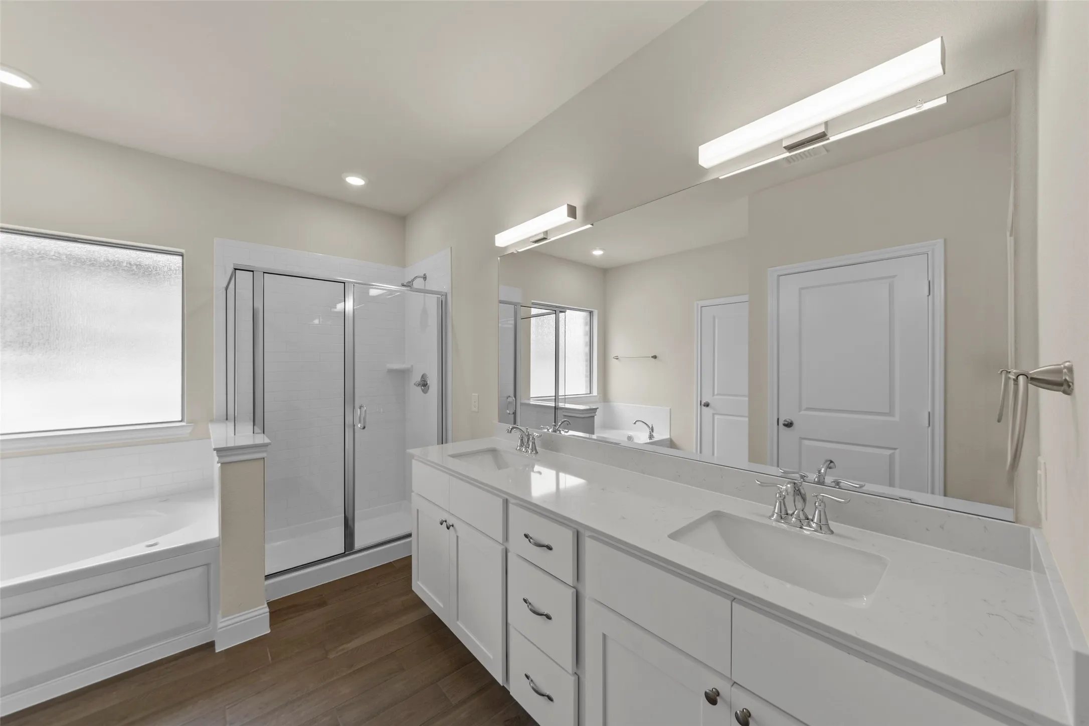 Double vanity with white cabinetry, integrated sinks, and polished chrome fixtures