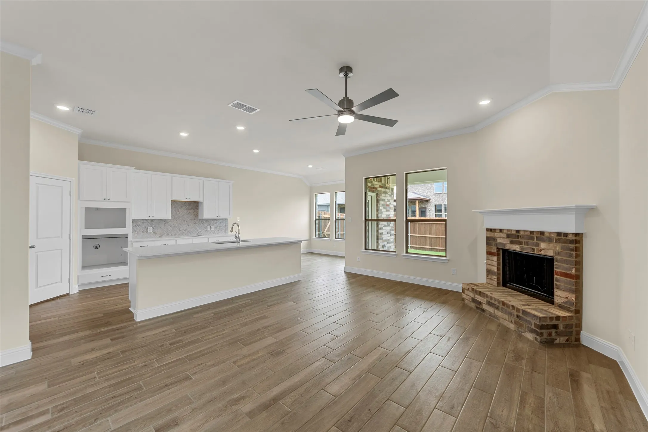Open-concept living space featuring wood-finish flooring, a contemporary ceiling fan, and recessed lighting