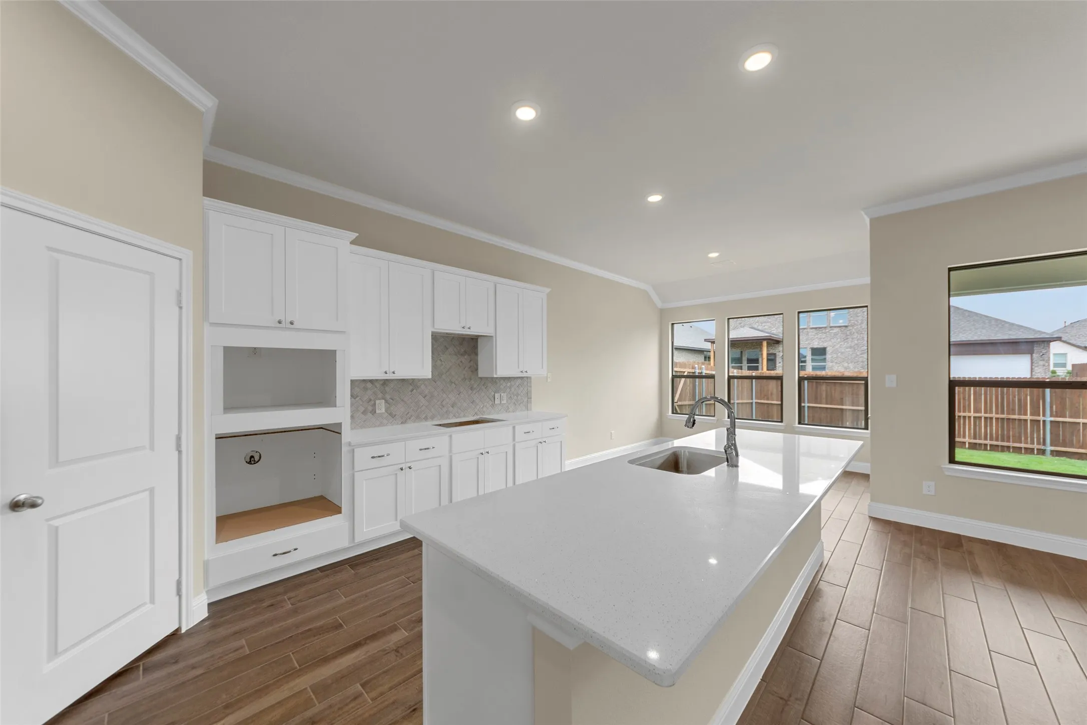 Open-concept kitchen featuring an expansive island with an undermount sink and gooseneck faucet