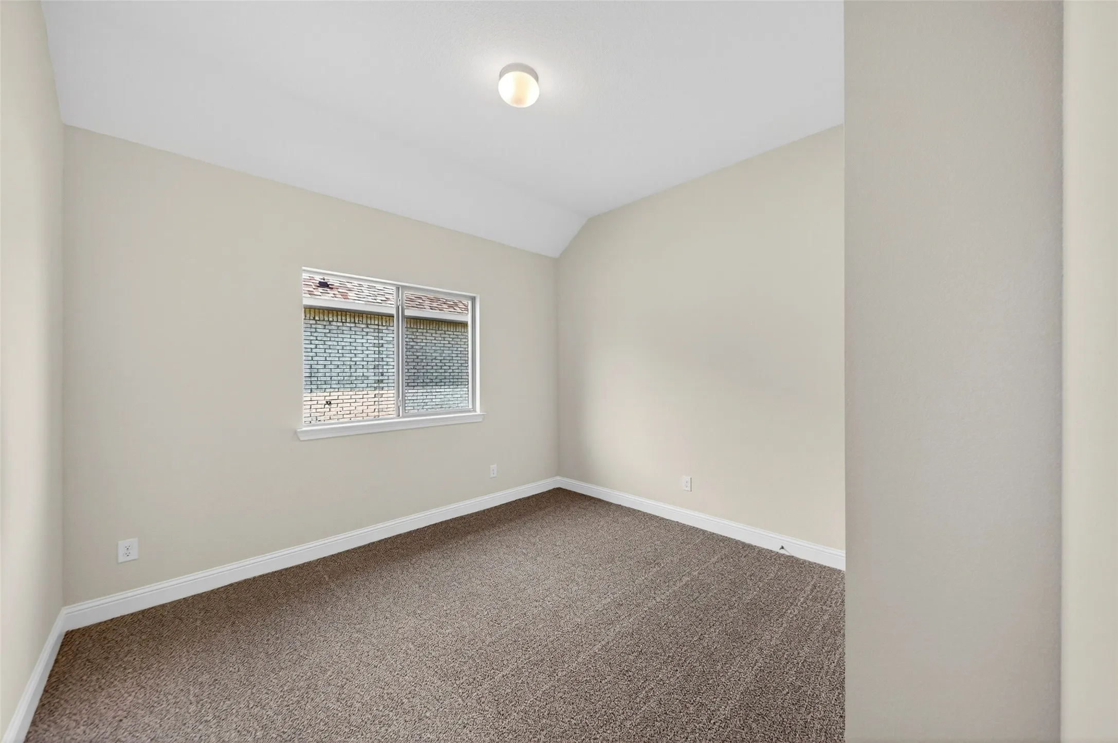 Neutral-toned interior room featuring light beige walls and textured brown carpeting