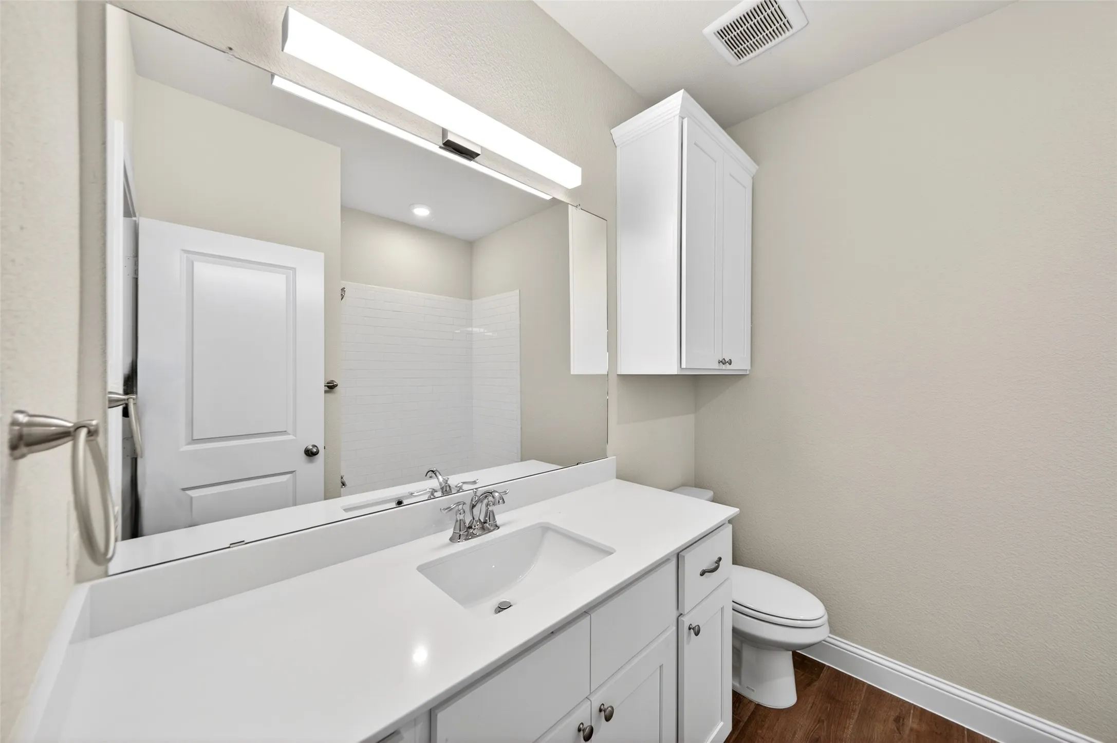 Bathroom featuring a vanity with an integrated sink, polished chrome faucet, and white countertop