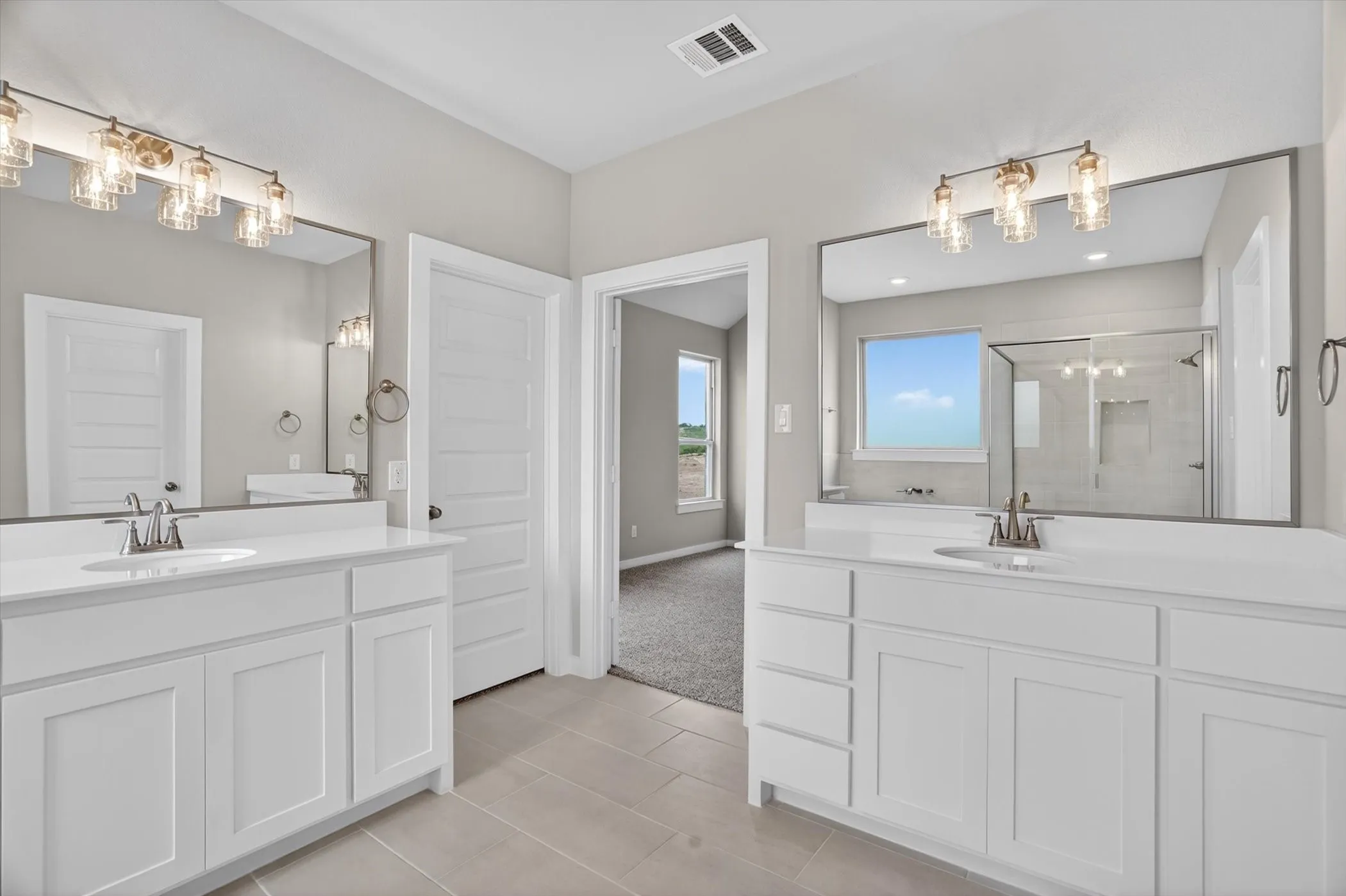 Dual vanities featuring white cabinetry, integrated sinks, and polished chrome fixtures