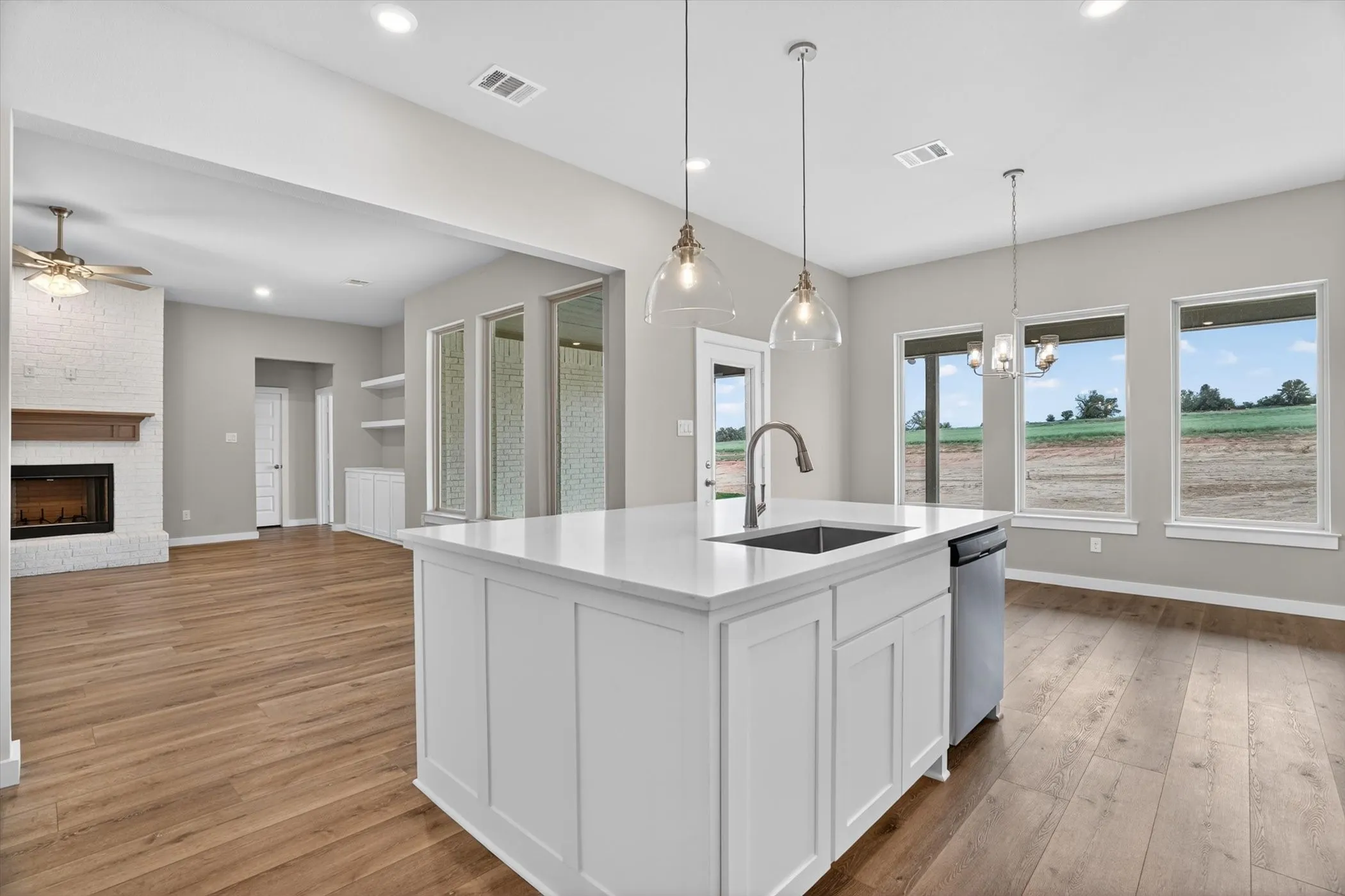 Modern kitchen island with a white solid surface countertop, undermount sink, and stainless steel dishwasher