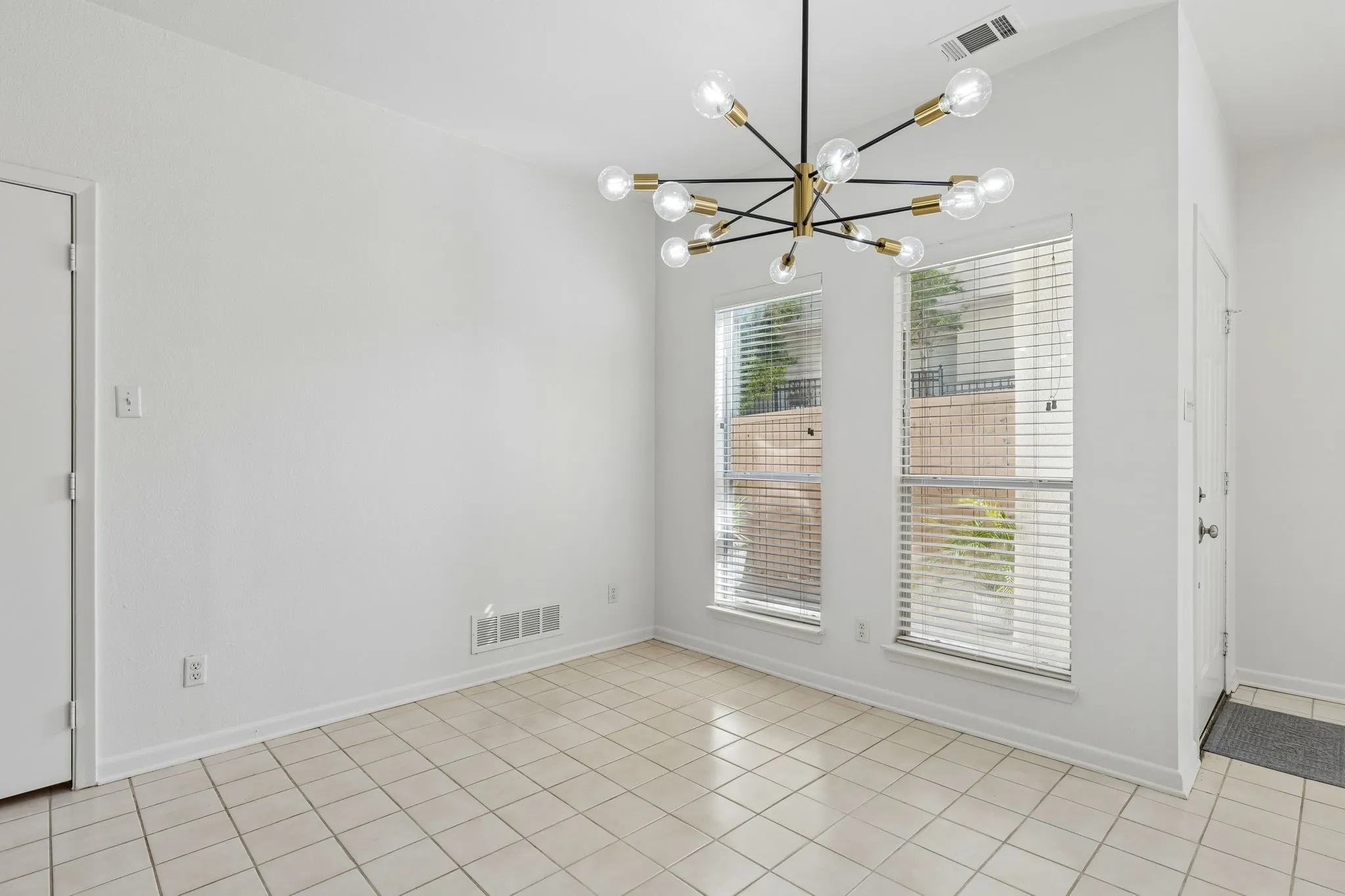 Unfurnished dining area featuring a chandelier and light ceramic tile patterned flooring
