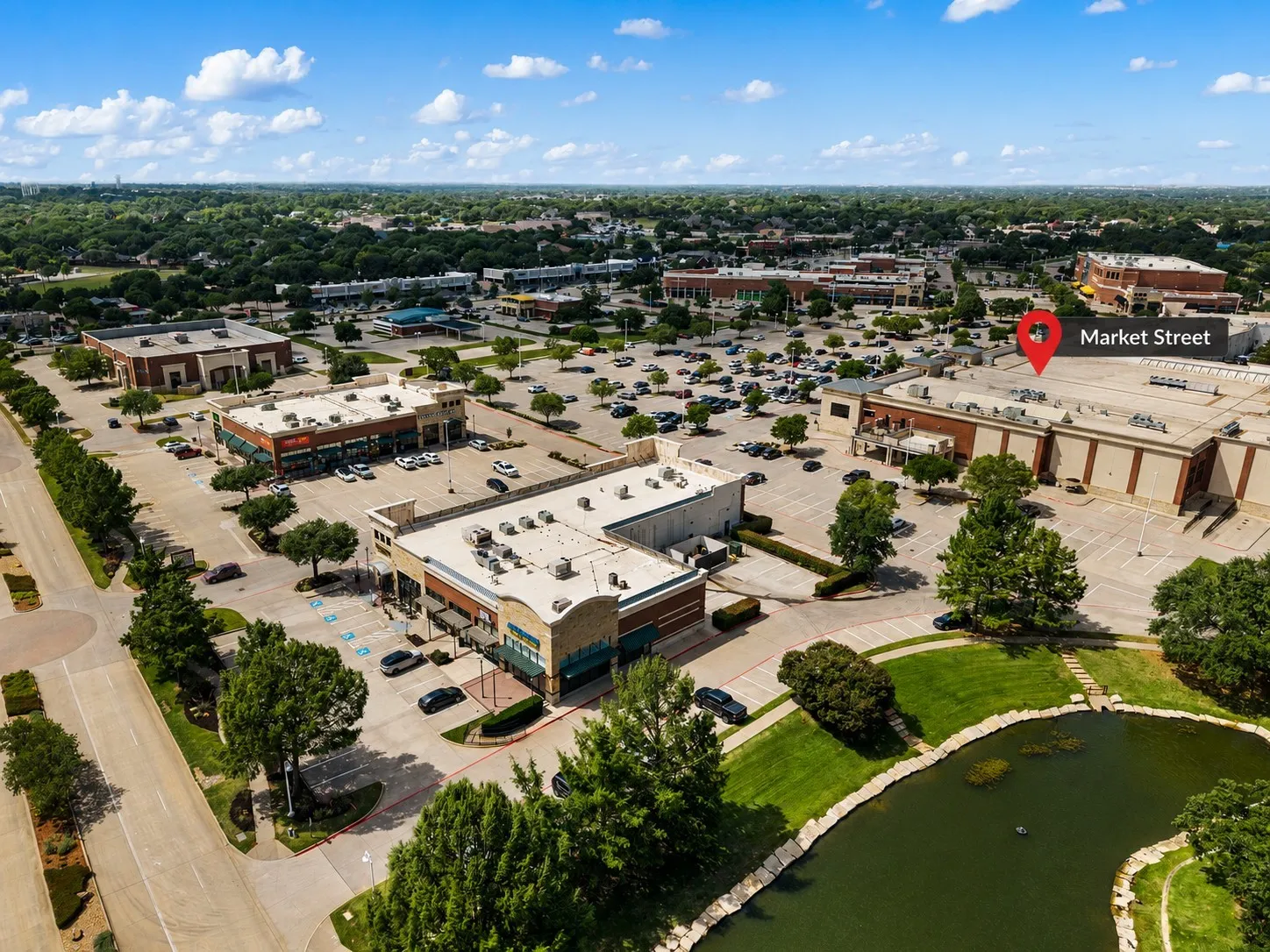 Aerial perspective showcasing a commercial development with multiple buildings and ample parking