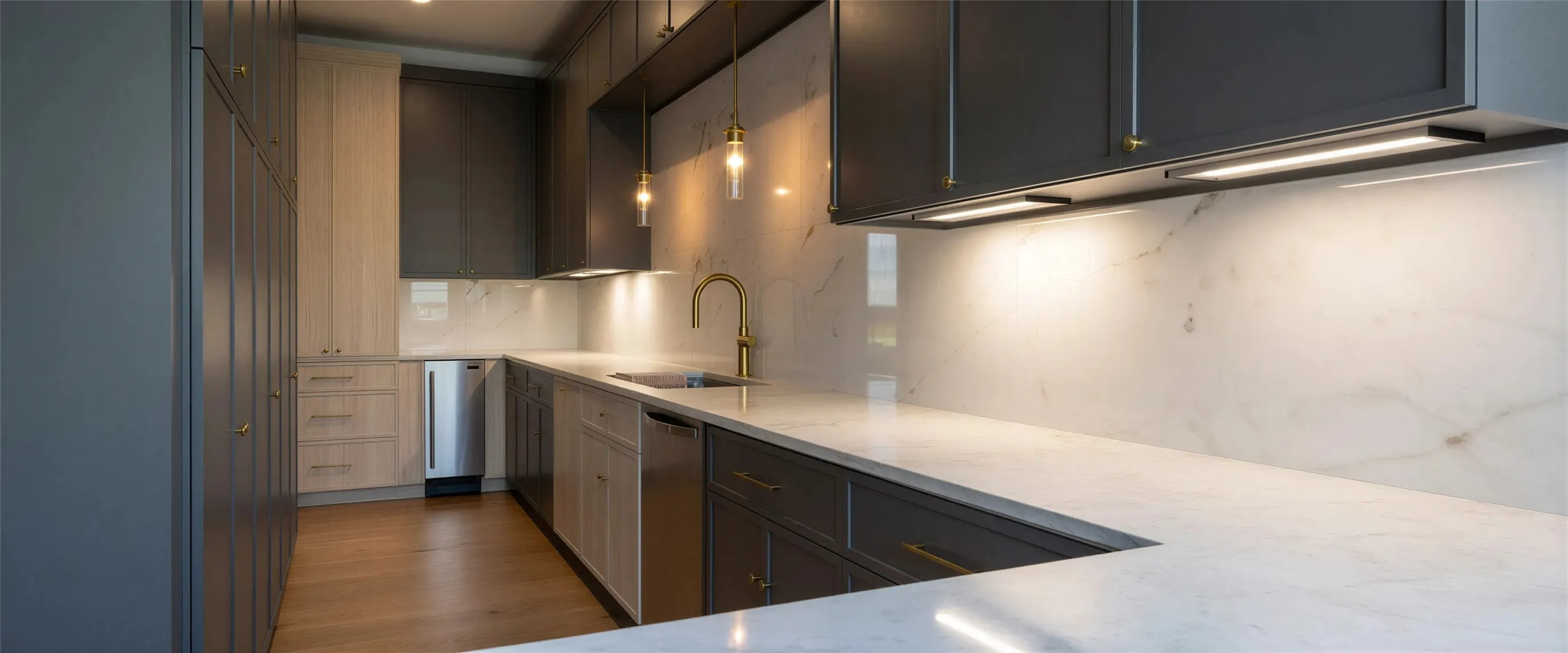 Kitchen featuring tasteful backsplash, dark wood finished floors, stainless steel appliances, light stone counters, and hanging light fixtures