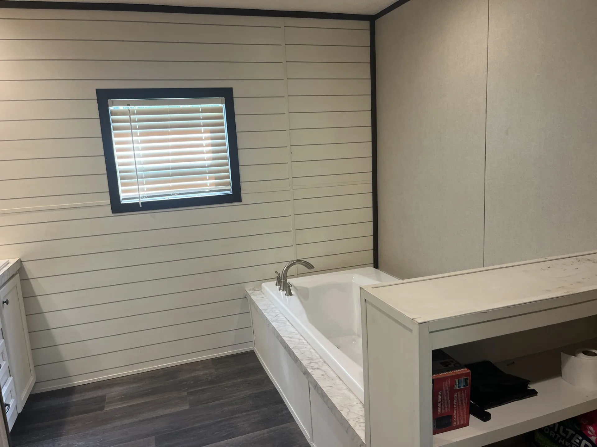 Bathroom with a garden tub, dark wood-style flooring, and vanity