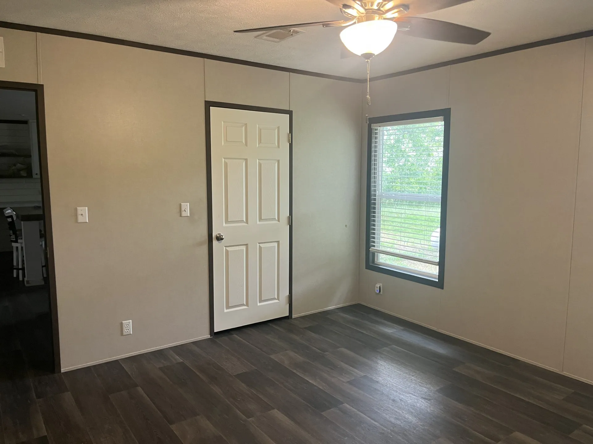 Bedroom featuring wood-finish flooring, a ceiling fan with integrated lighting, and a window with blinds