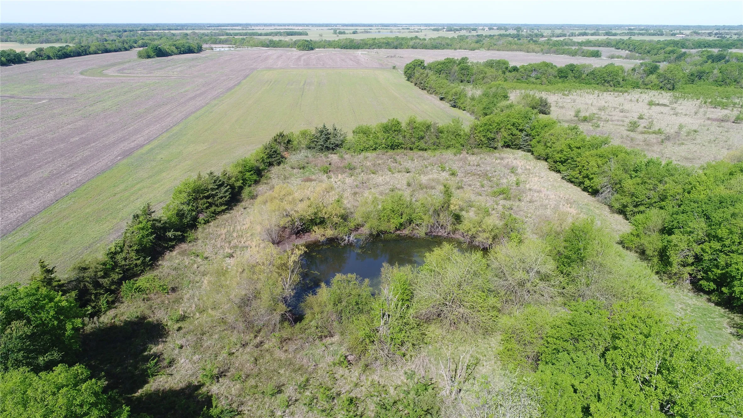 View of rural area featuring large plots for crops and a large body of water