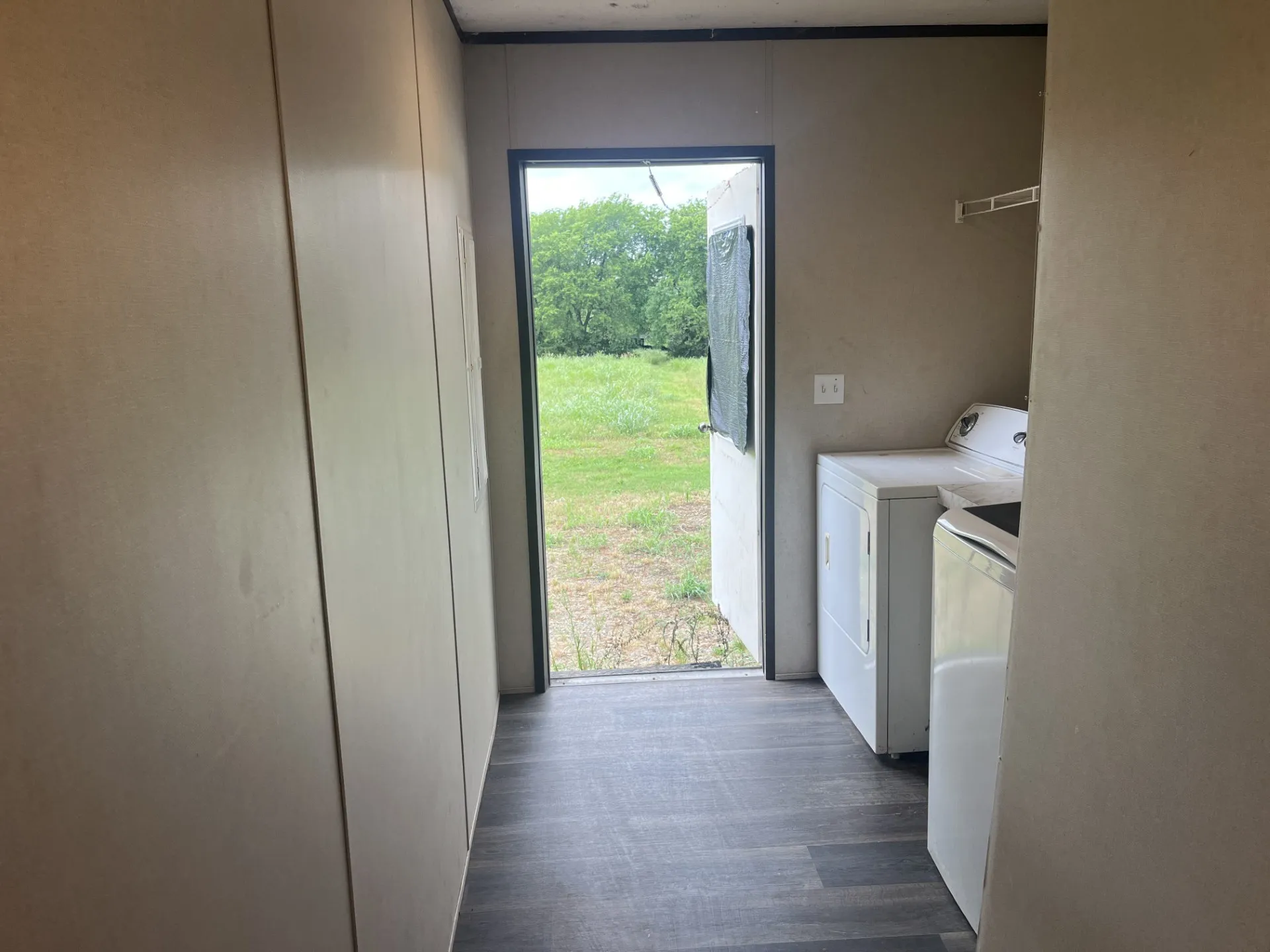 Utility area featuring wood-finish flooring and a rear exterior door