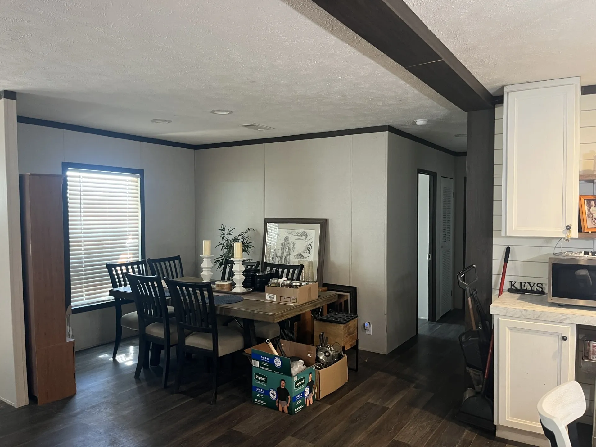 Bedroom featuring dark wood-style floors, a ceiling fan, a decorative wall, and ornamental molding