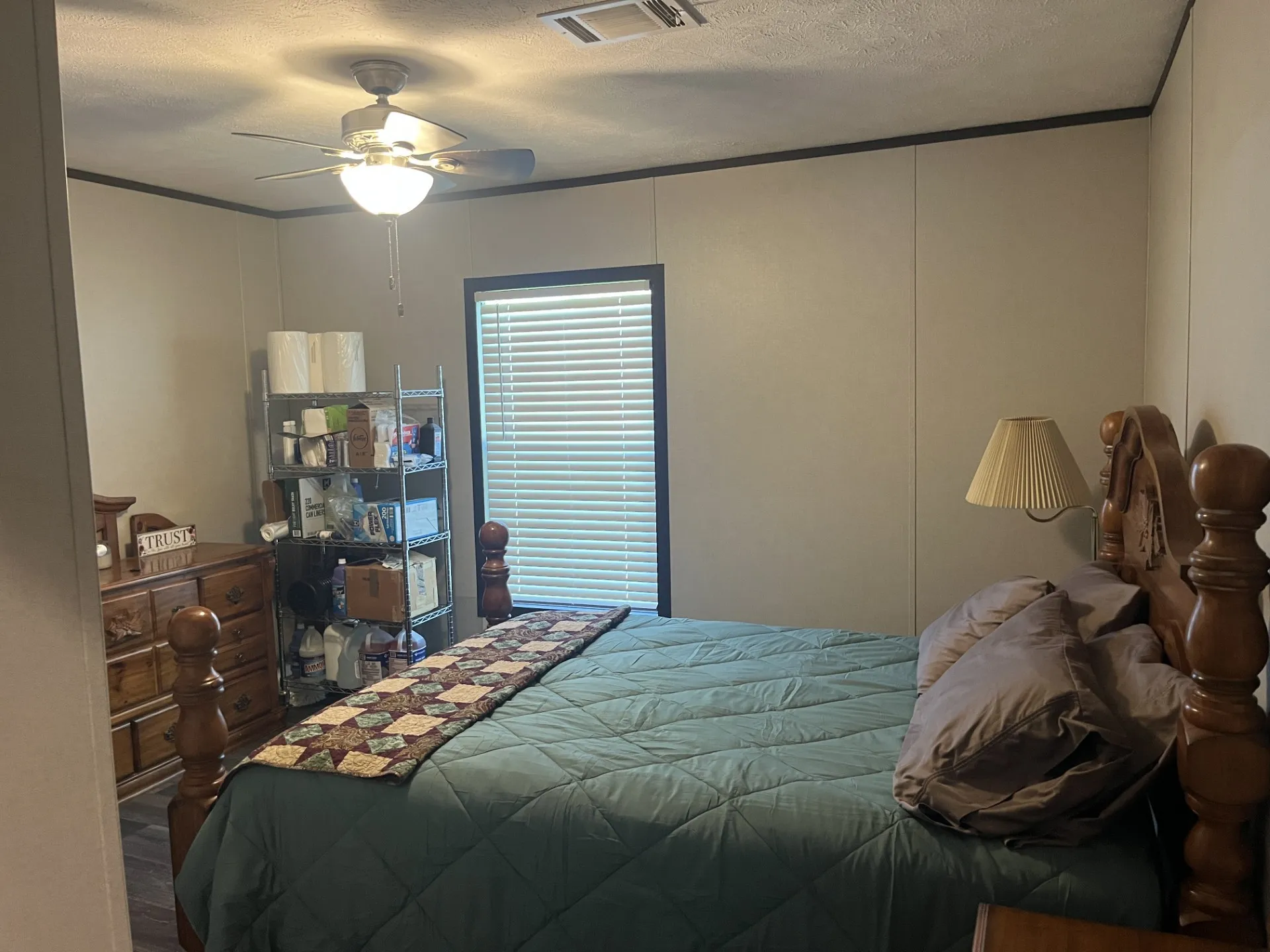 Bedroom with ornamental molding, a textured ceiling, a ceiling fan, and a decorative wall
