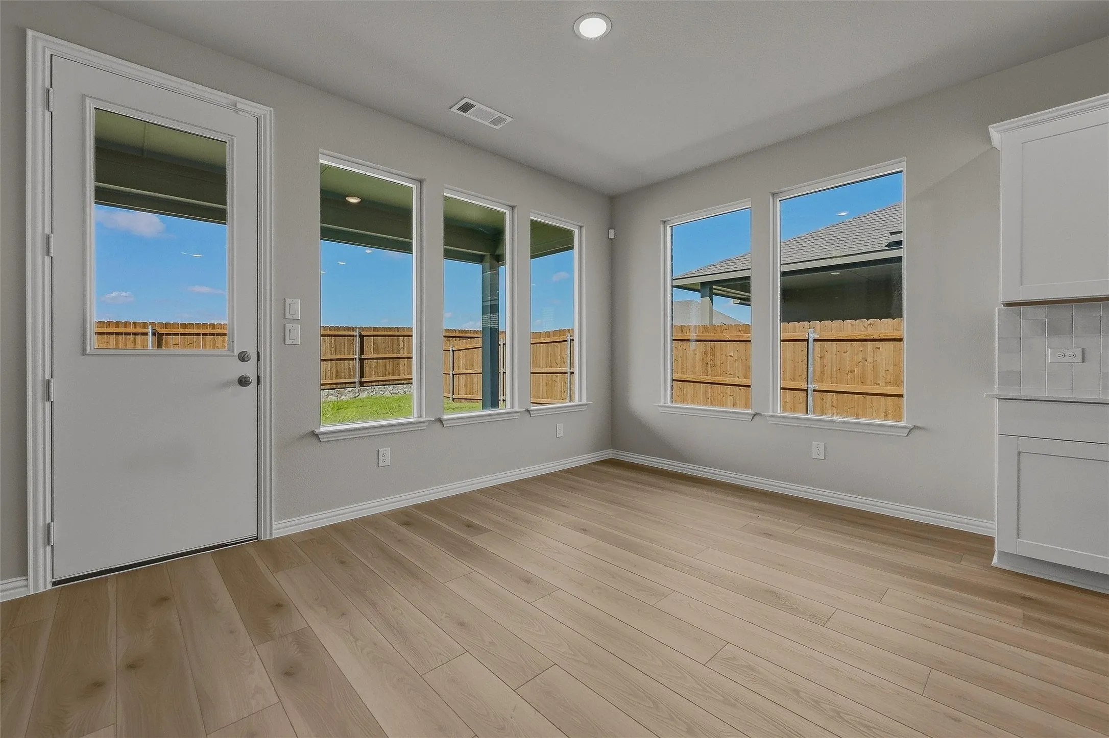 Wood-finish flooring, recessed lighting, and multiple windows