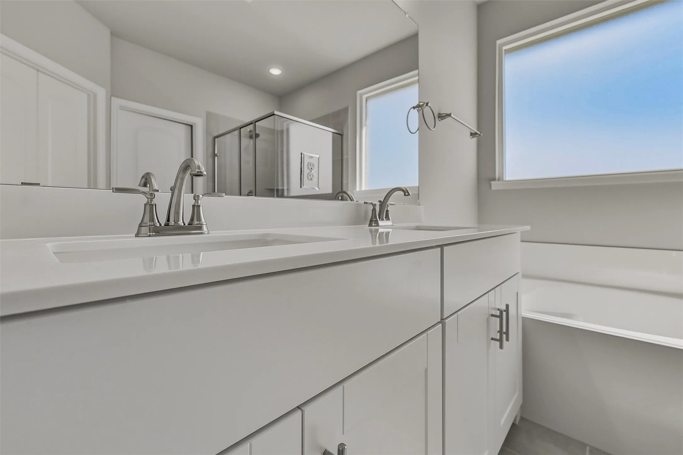 Dual vanity with undermount sinks, white cabinetry, and brushed nickel hardware